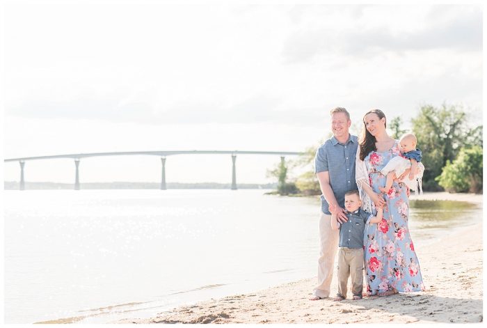 family on the beach in front of the Solomons island bridge