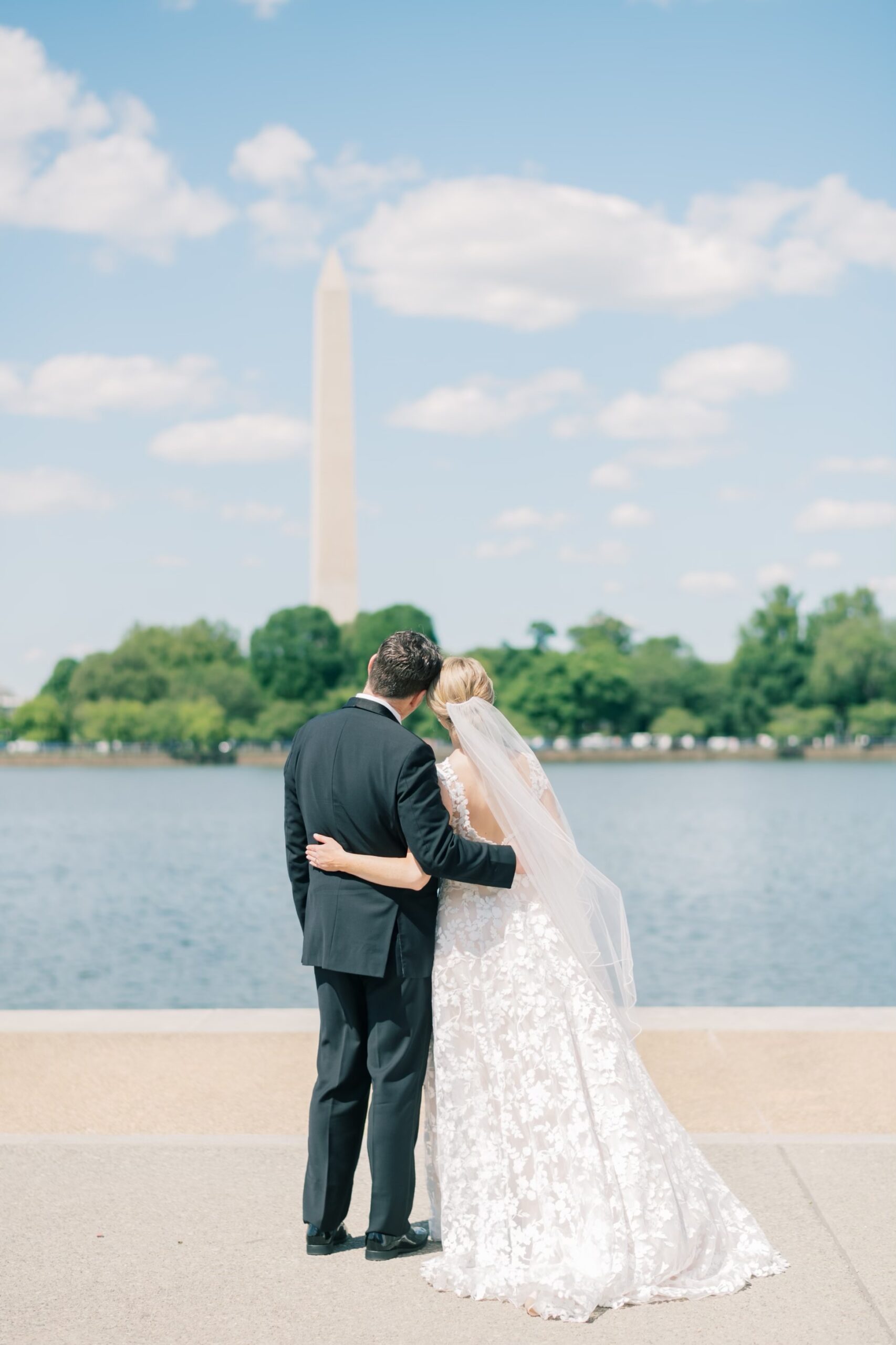 Portrait of a bride and groom at the Tidal Basin in DC looking at the Washington Monument