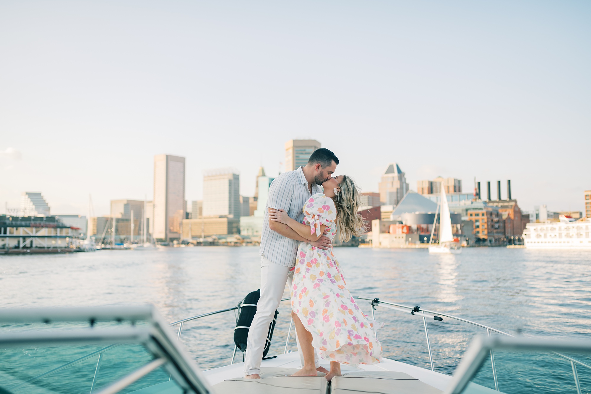 engaged couple kisses on front of boat during Inner Harbor engagement session 