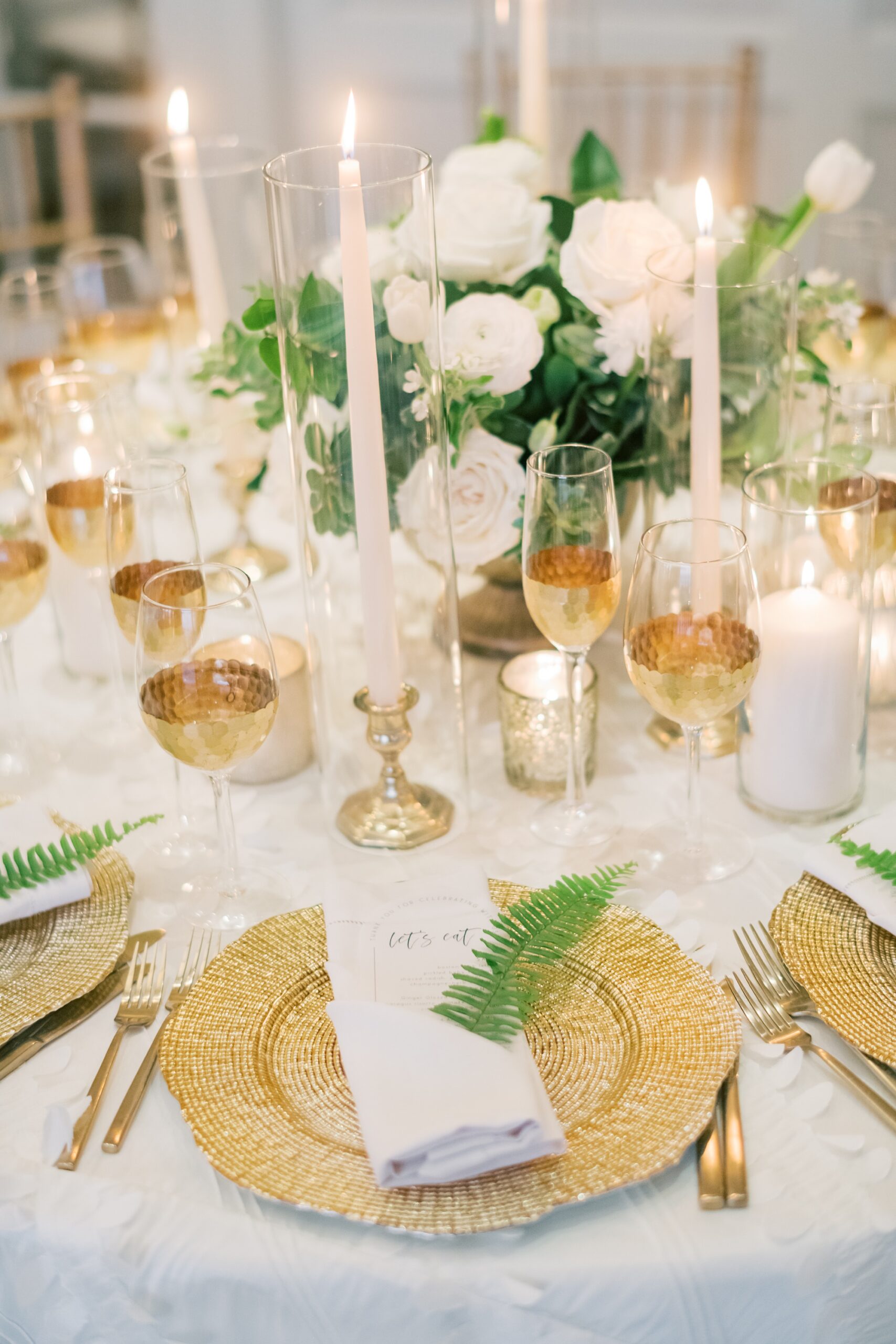 place setting with gold plates, white flowers and greenery at the Hay Adams Hotel