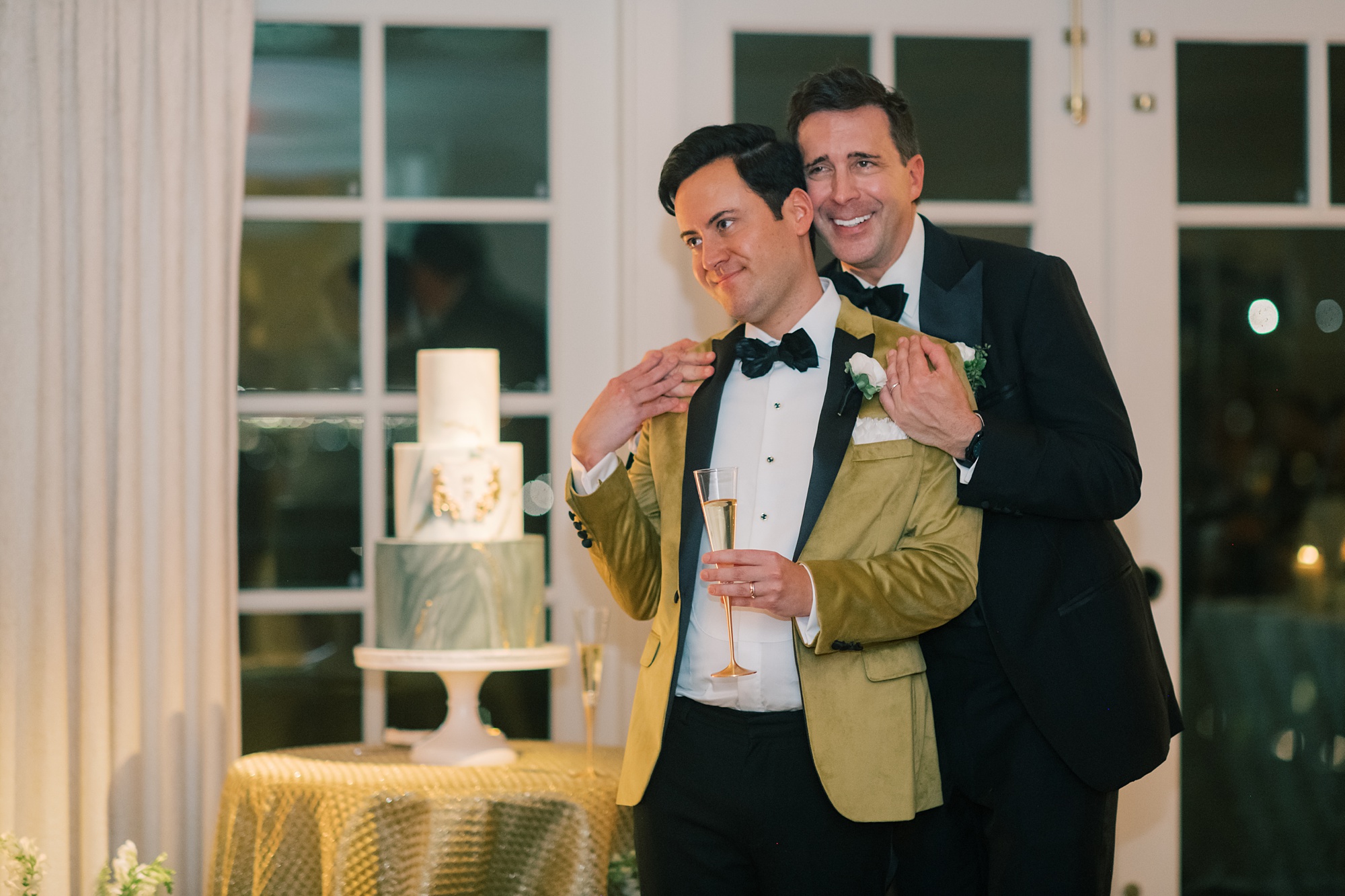 groom hugs husband in gold jacket during reception at the Hay Adams Hotel