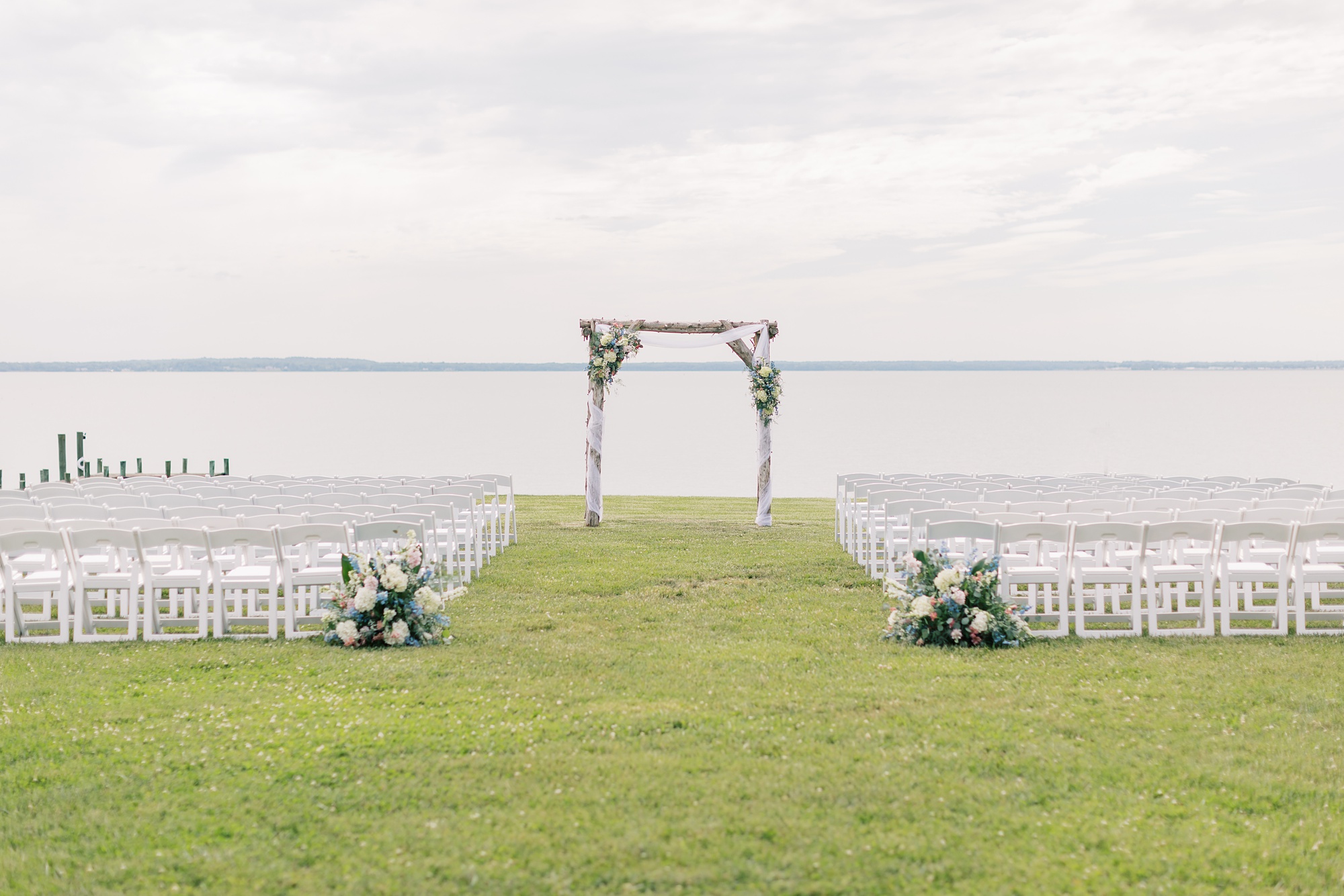 wedding ceremony on lawn with wooden arbor at the Pavilion at Weatherly