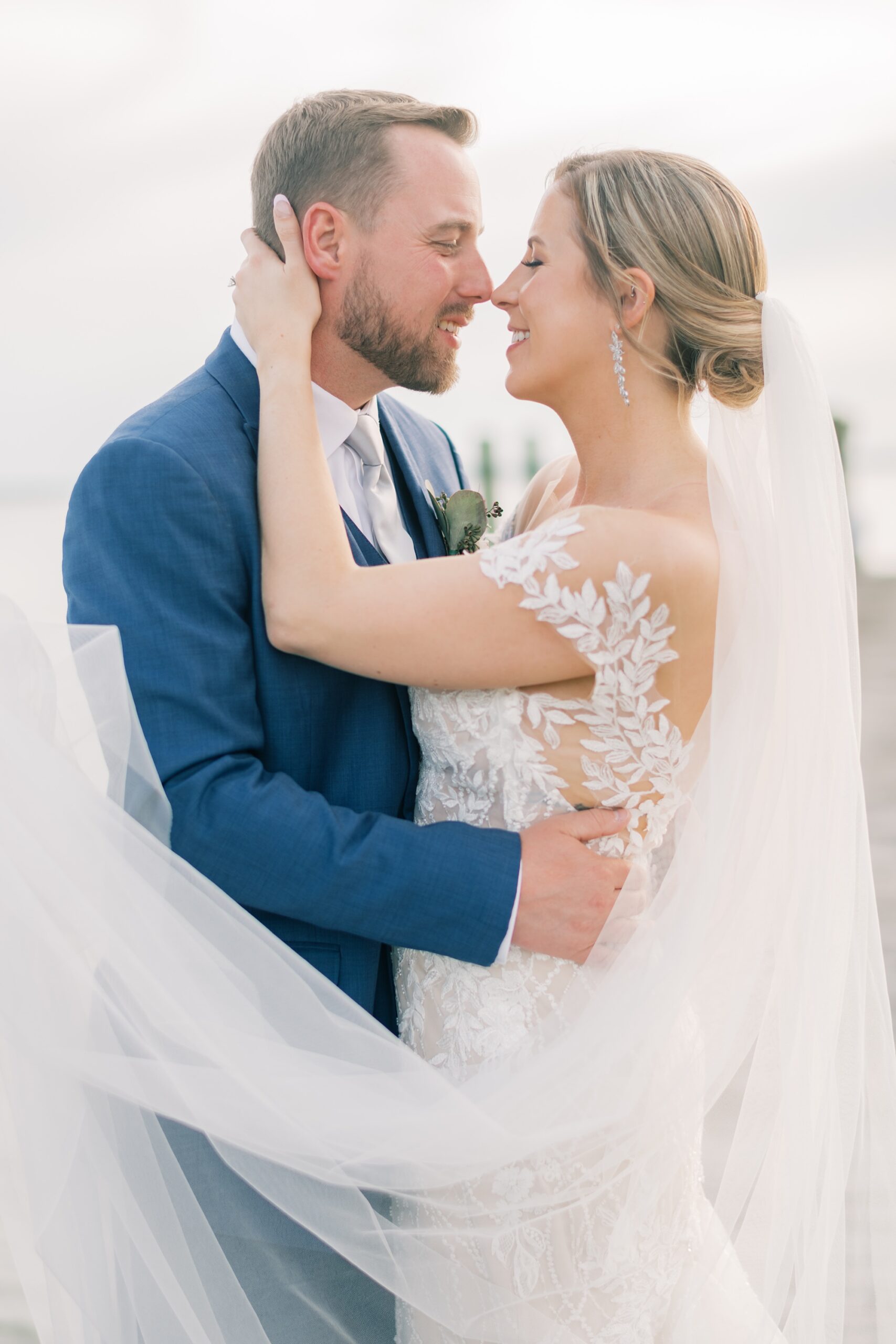 newlyweds kiss with bride's veil floating around them 
