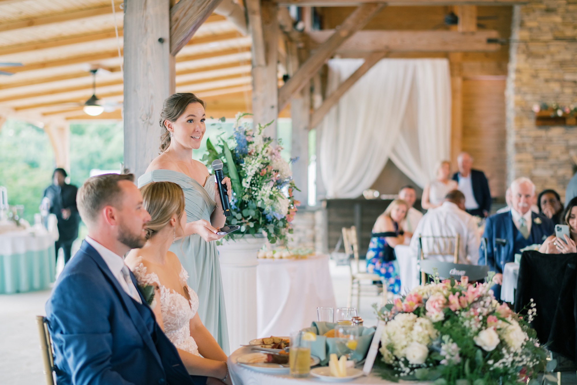 bridesmaid in mint dress gives speech to newlyweds at the Pavilion at Weatherly