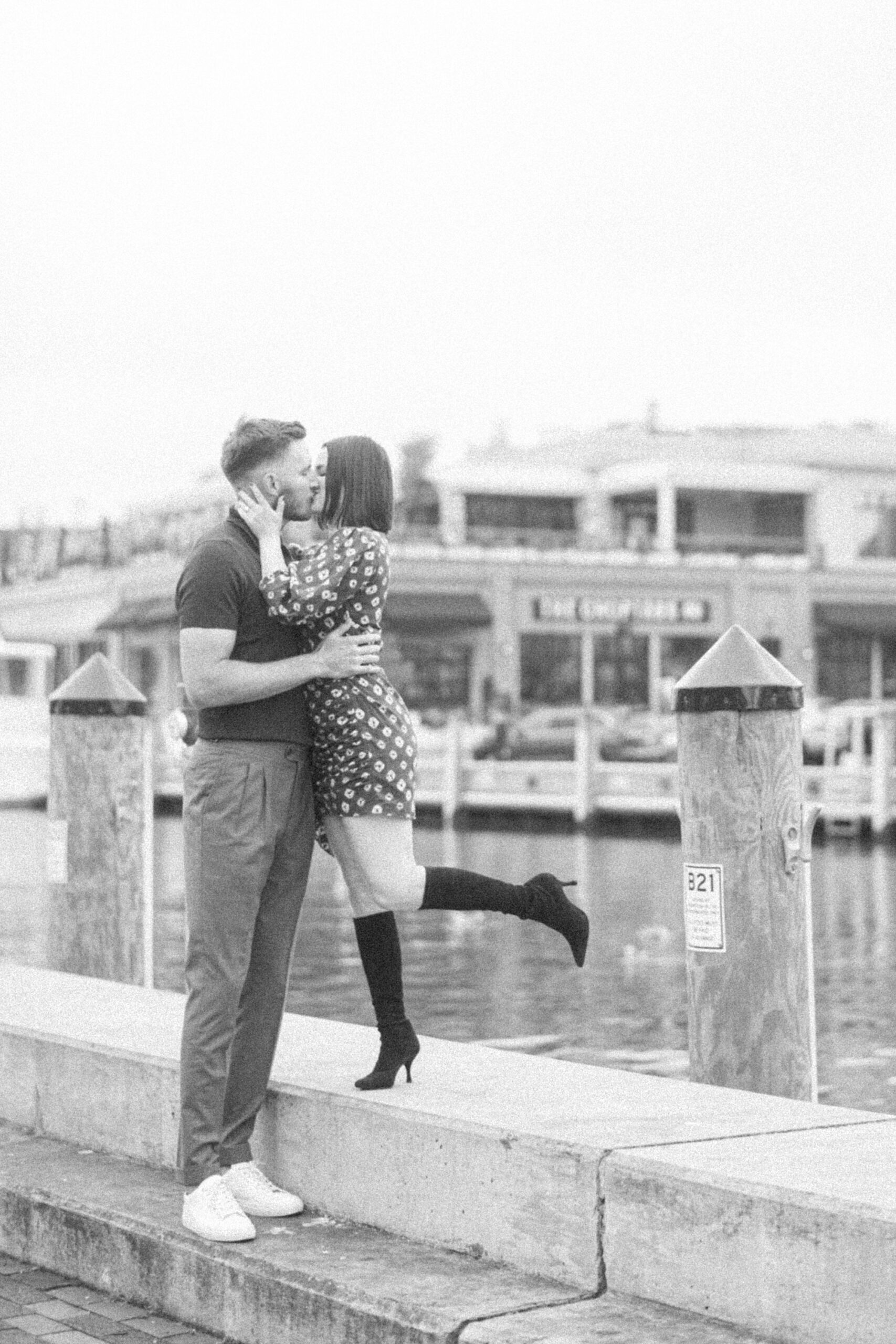 woman leans to kiss fiancee along Downtown Annapolis waterfront