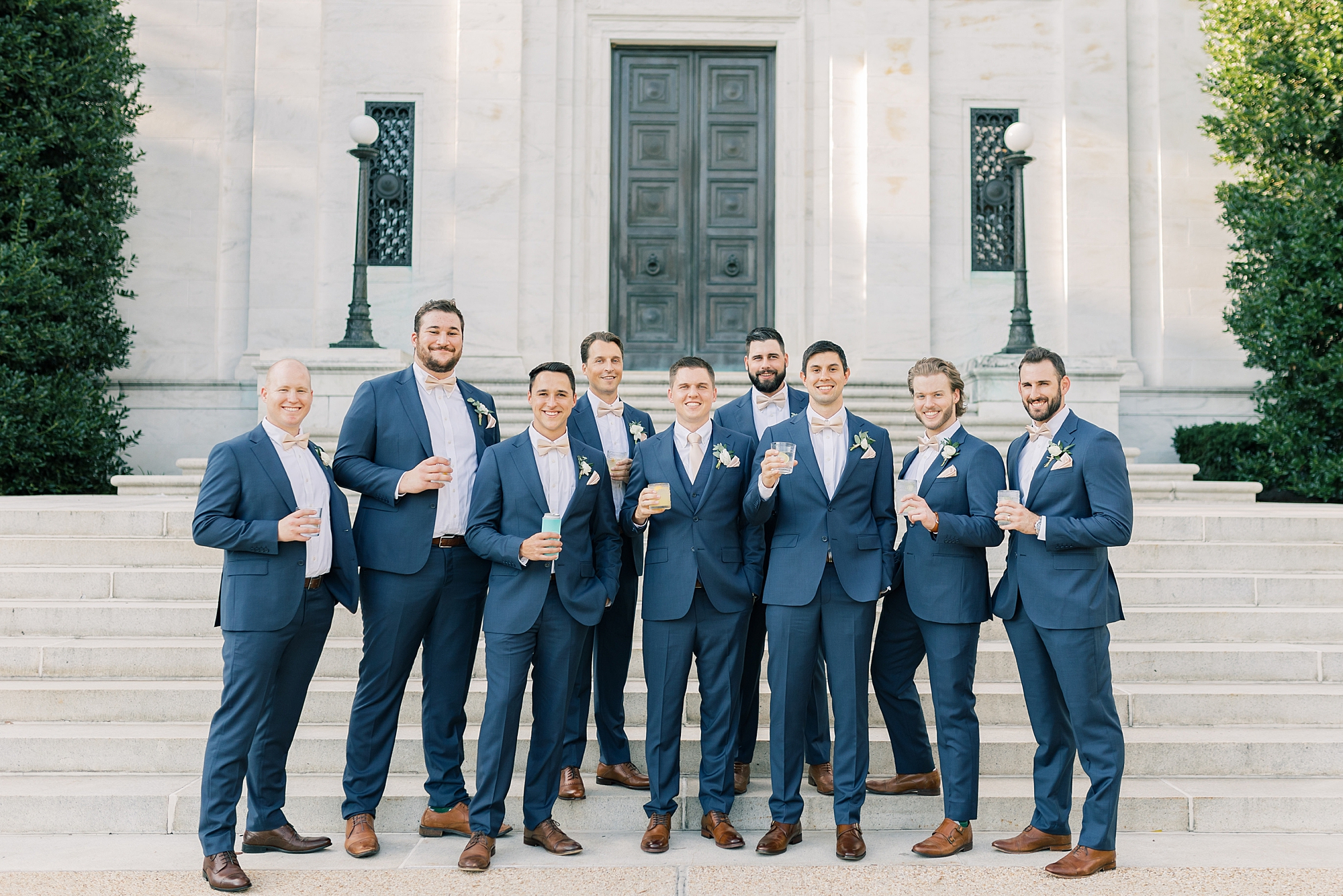 groom and groomsmen in blue suits pose outside DC church 