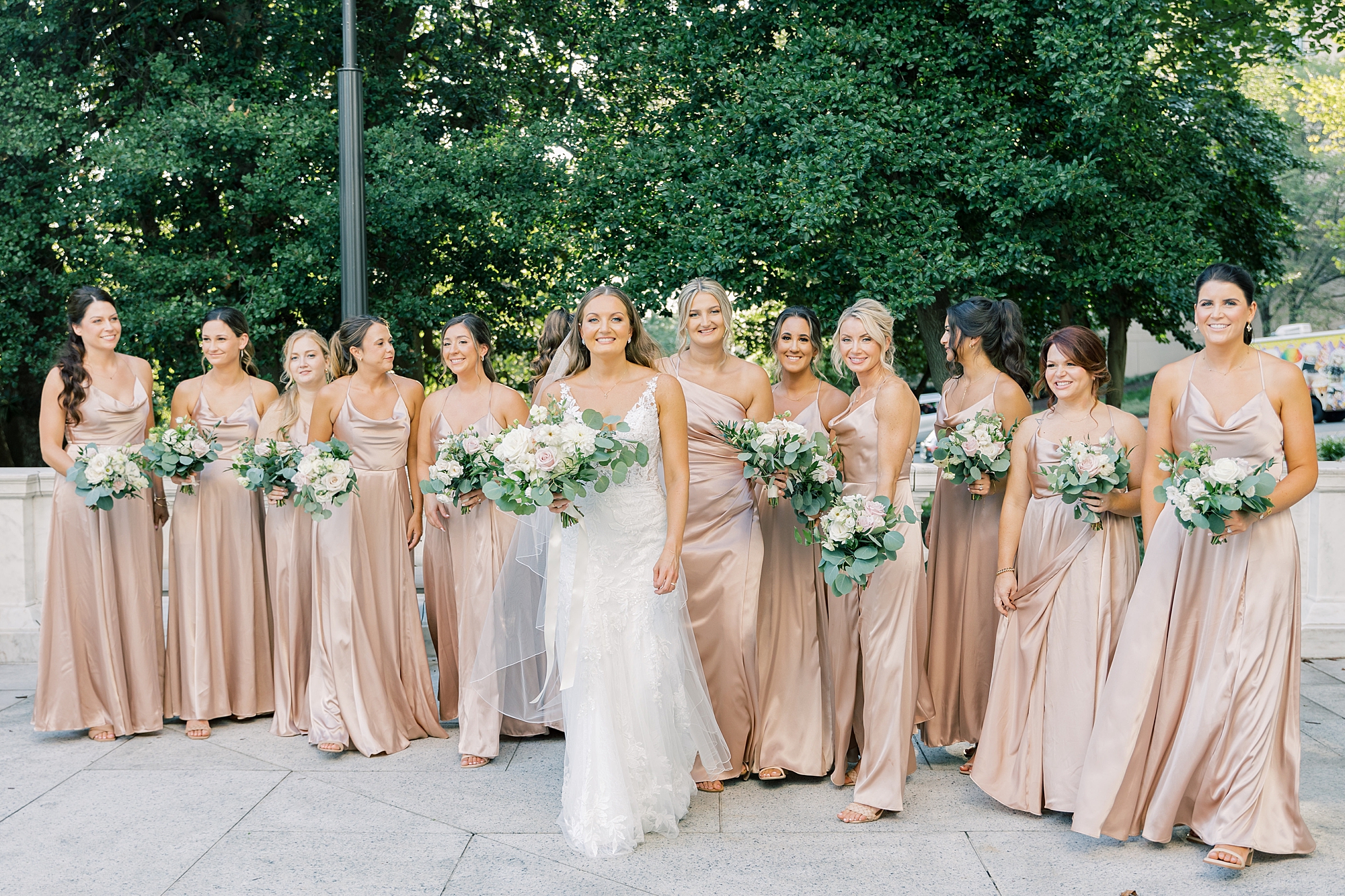 bride walks with bridesmaids in champagne gowns on street in DC