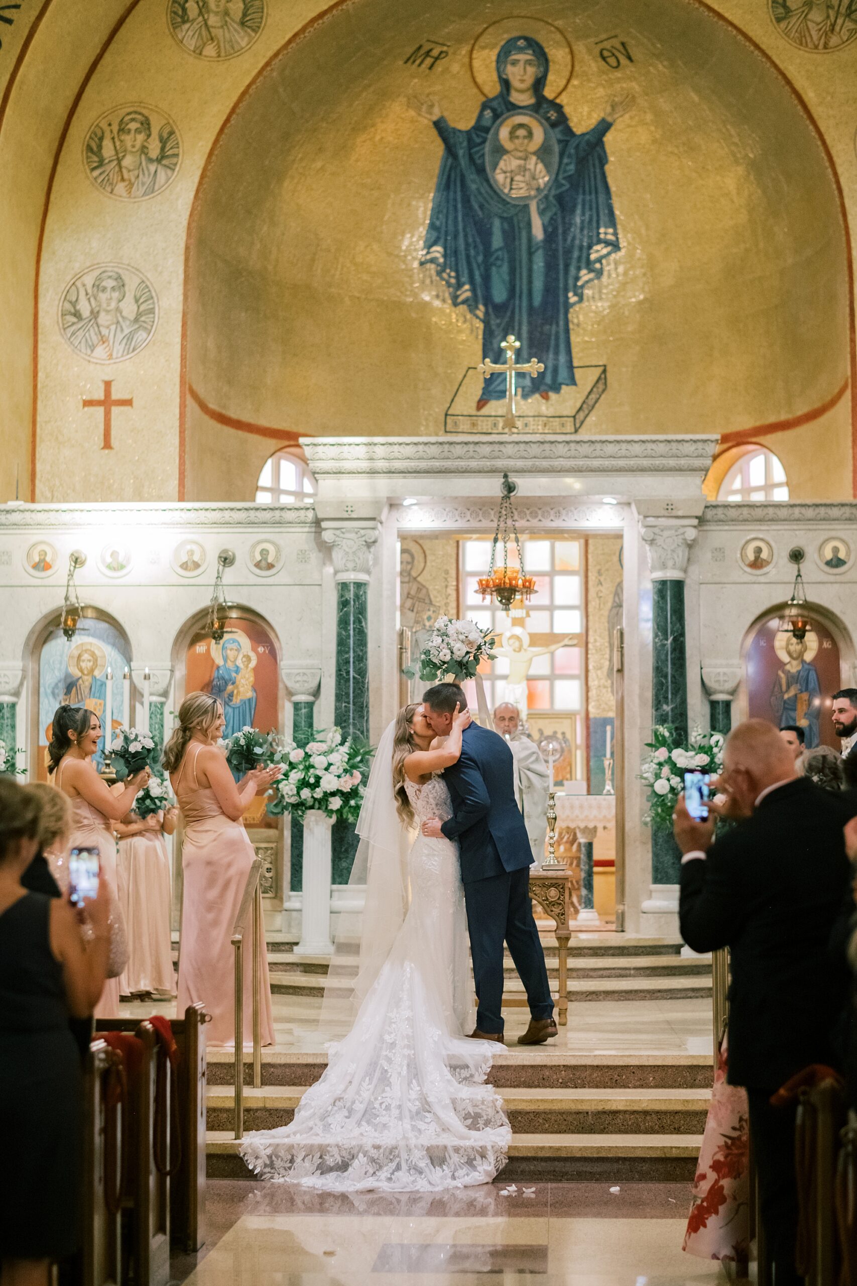 couple kisses after traditional Greek Orthodox wedding ceremony in Washington DC