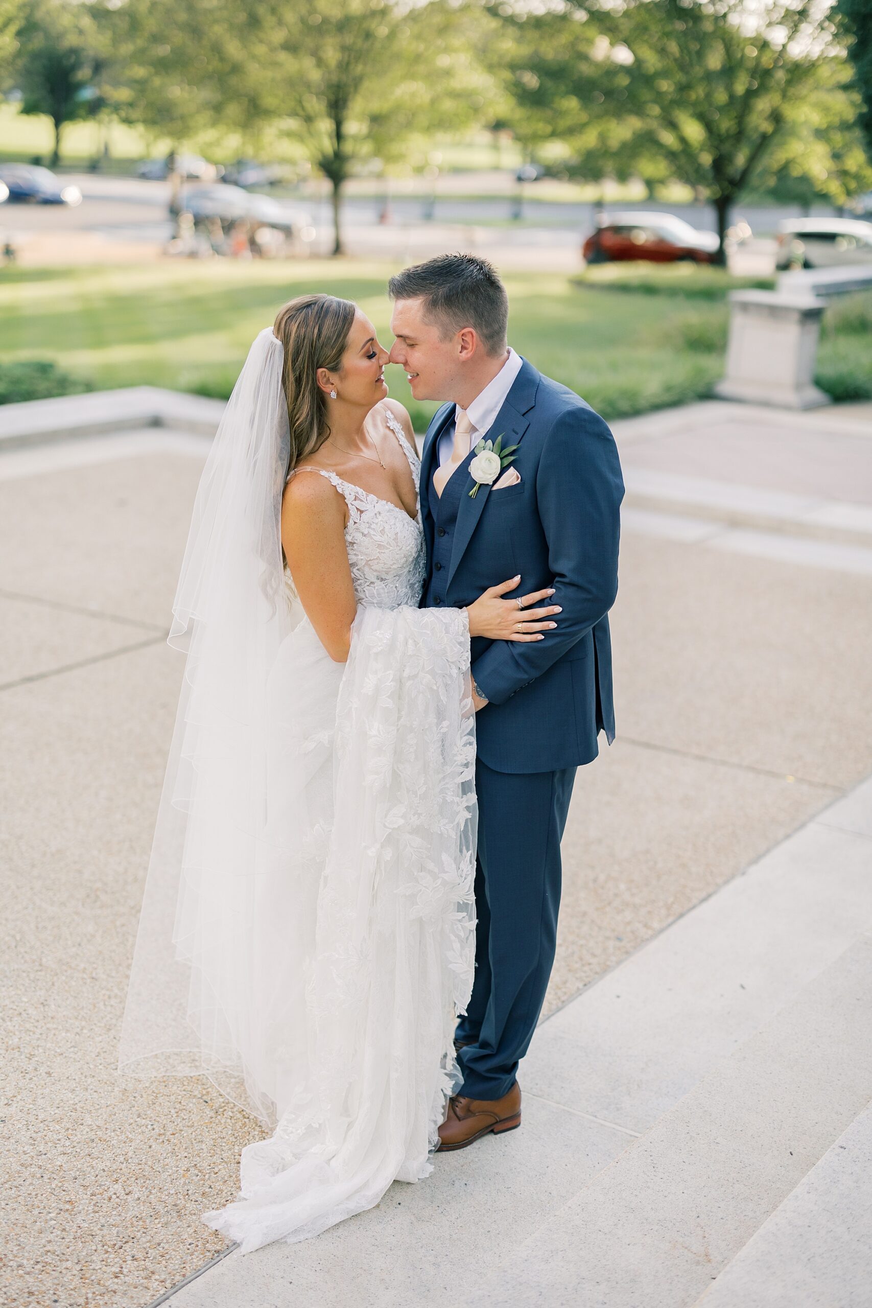 newlyweds lean together nuzzling noses on steps of Potomac View Terrace