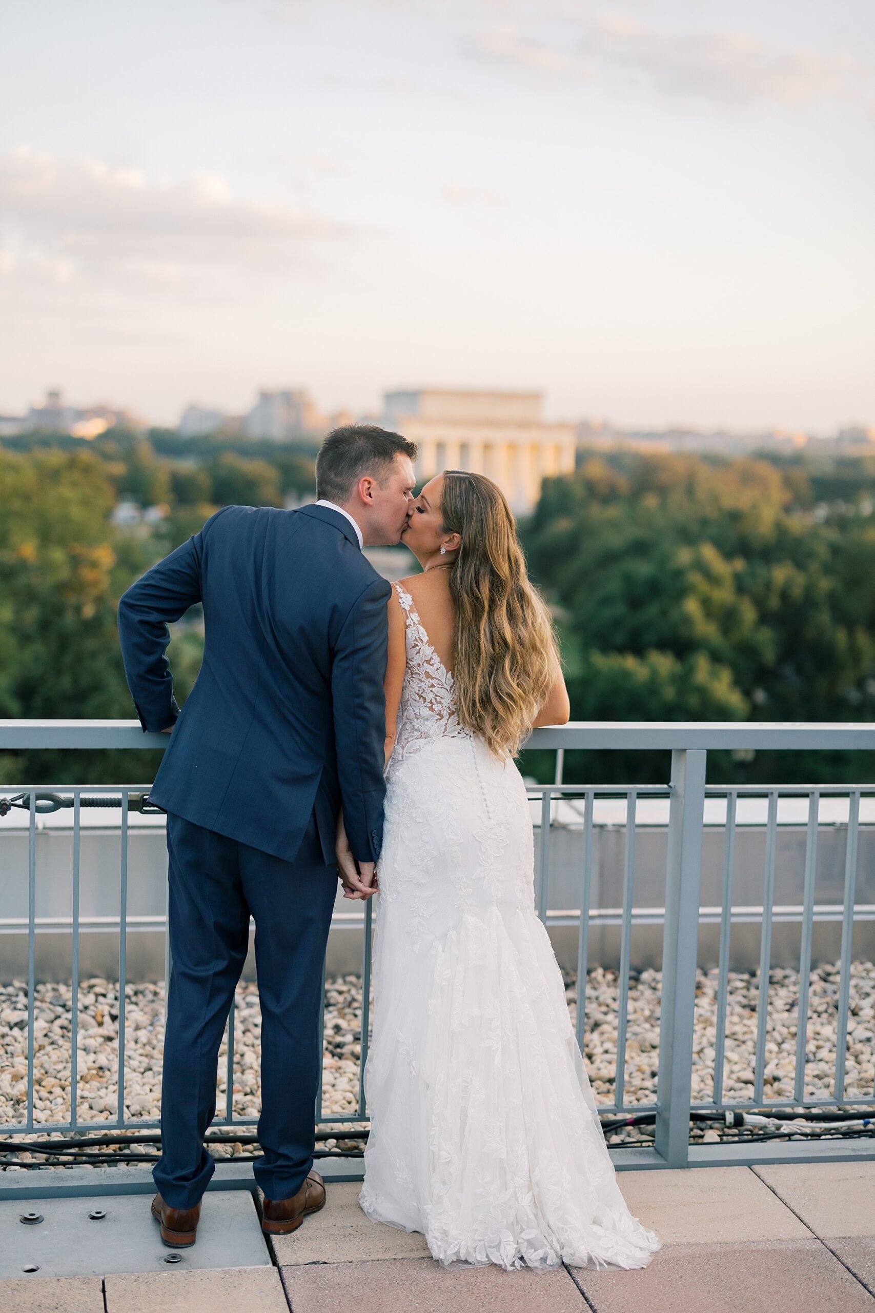bride and groom kiss on balcony of Potomac View Terrace