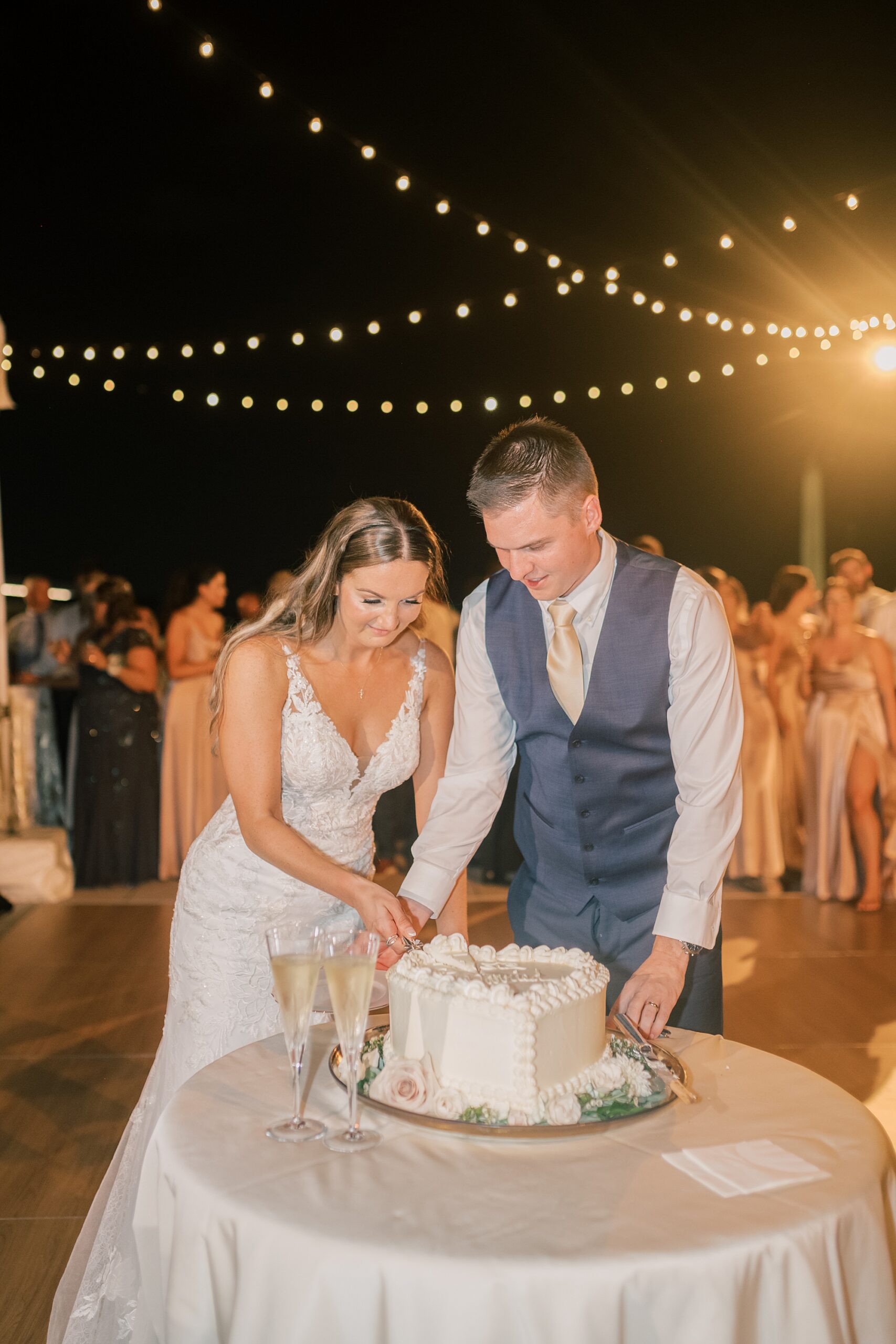 bride and groom cut wedding cake on patio of Potomac View Terrace