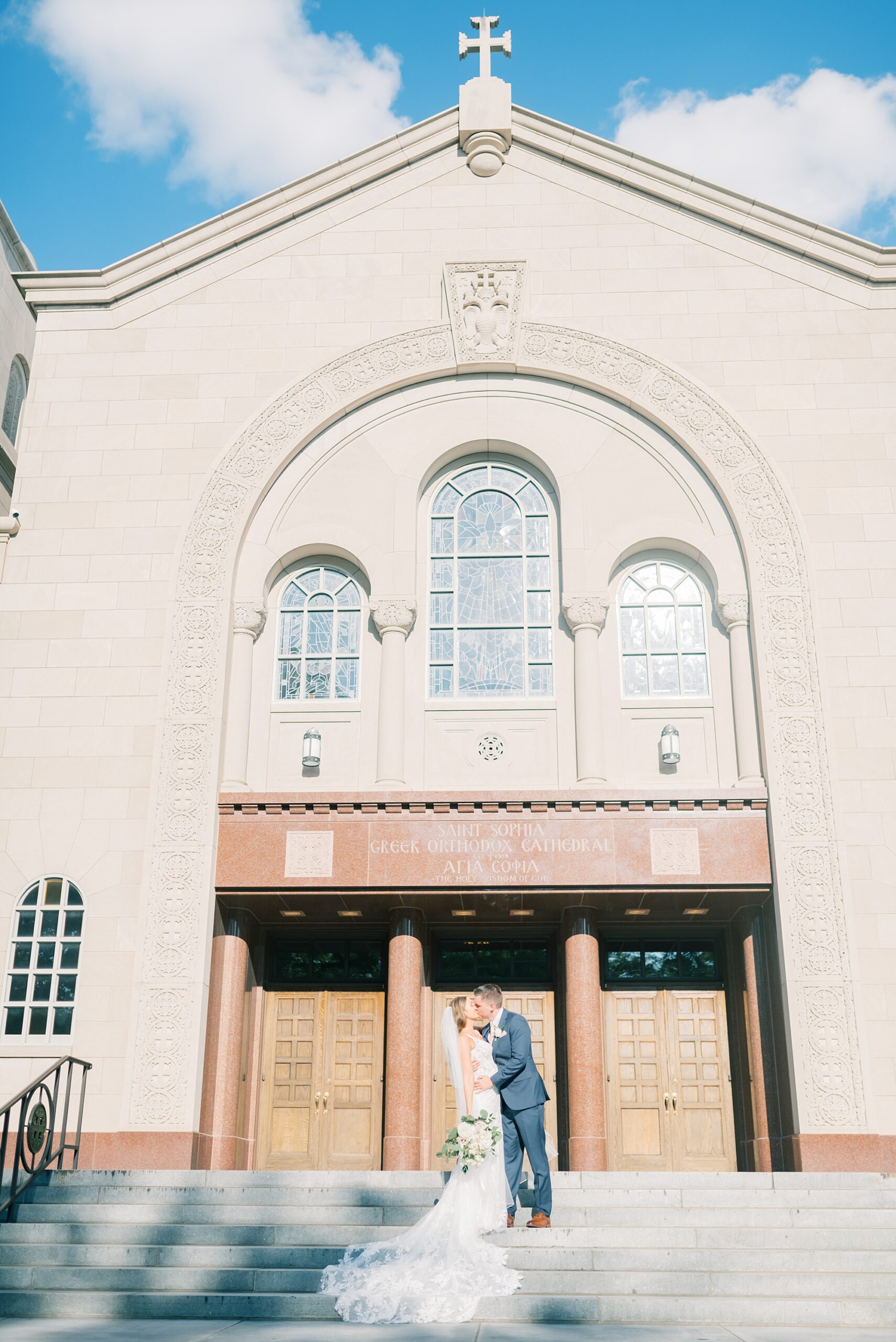 bride and groom kiss on steps of Greek Orthodox church in Washington DC
