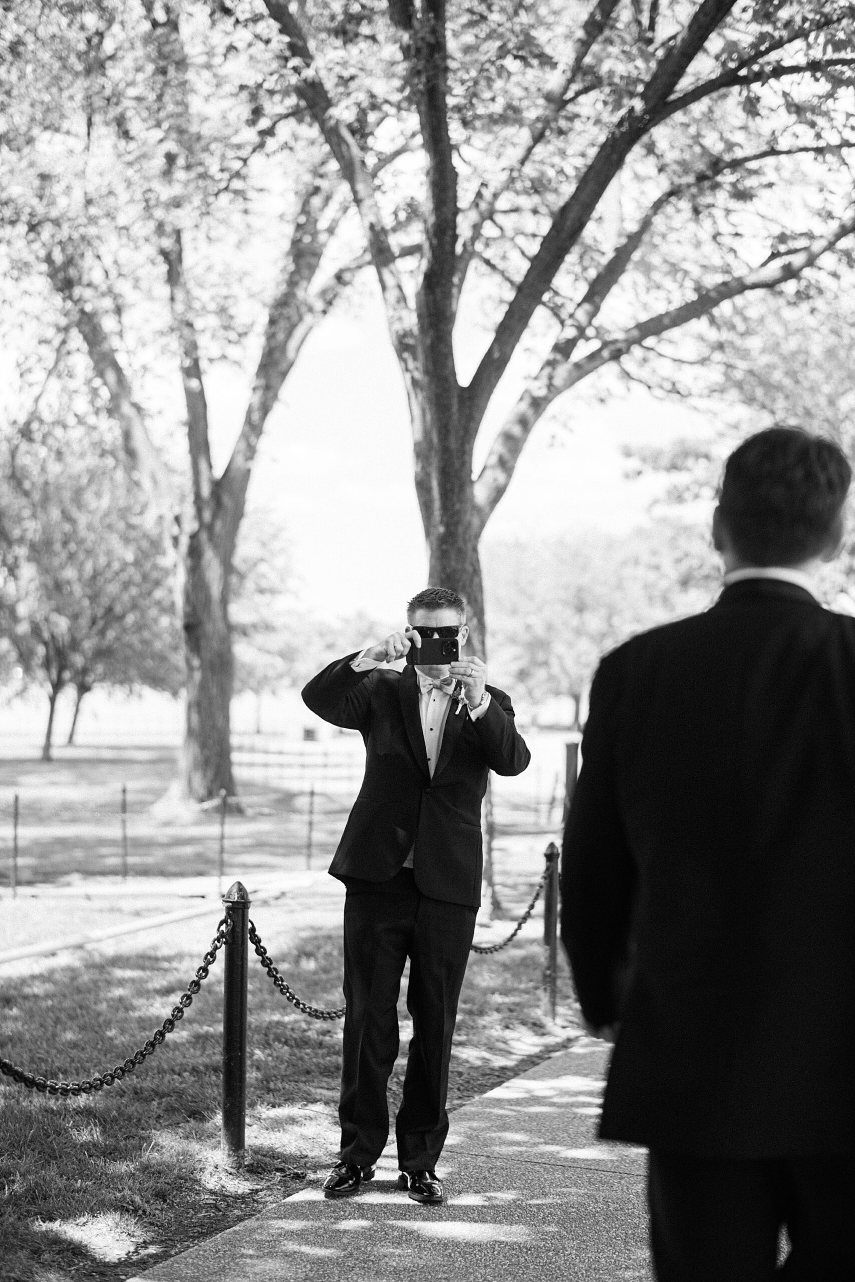man takes photo of couple on walk in Washington DC