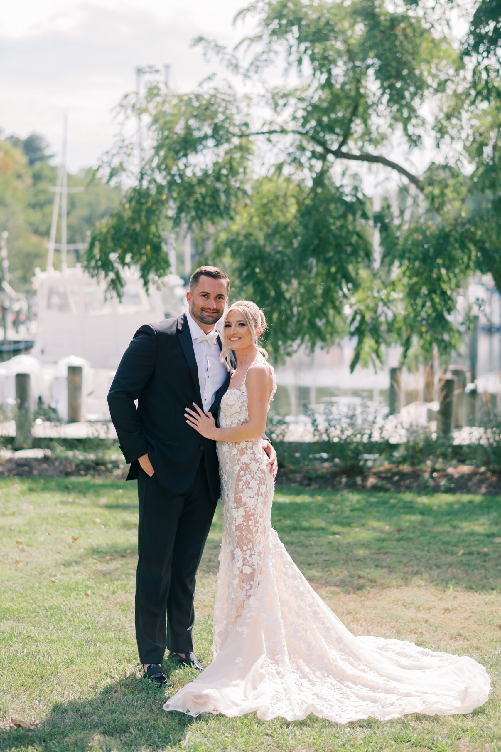 bride and groom hug in front of docks at Herrington on the Bay