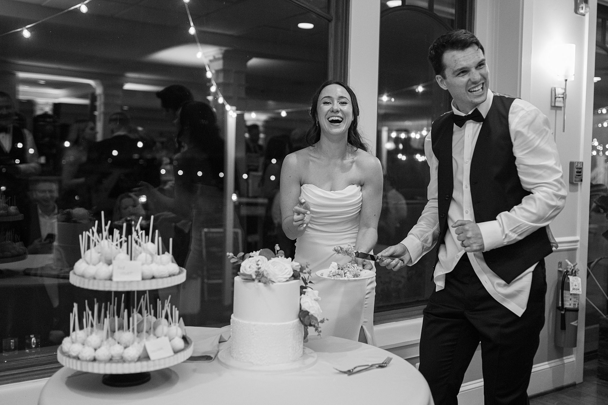 newlyweds cut wedding cake during North Beach MD wedding reception