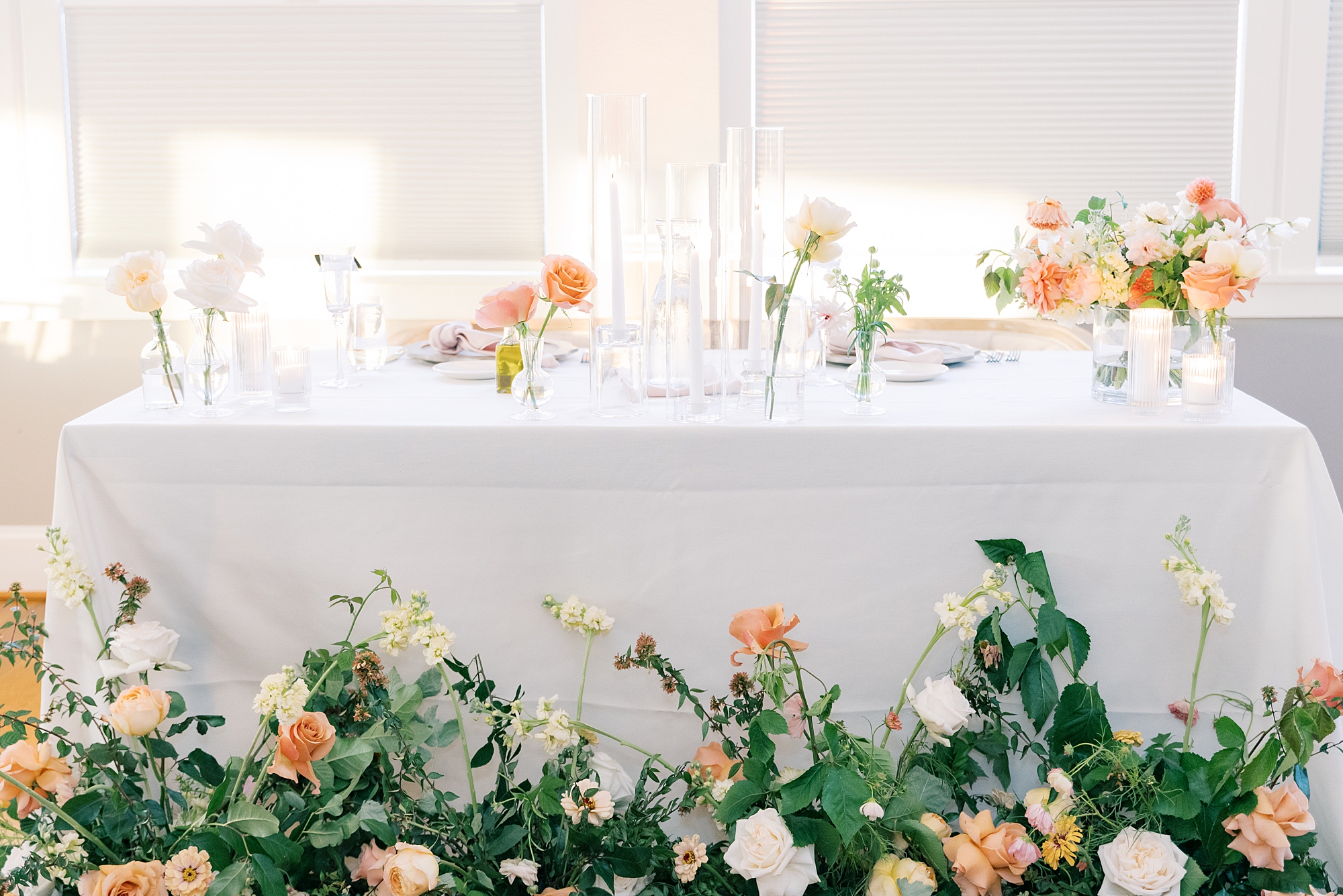 sweetheart table for fall wedding with pastel flowers and sprays of greenery