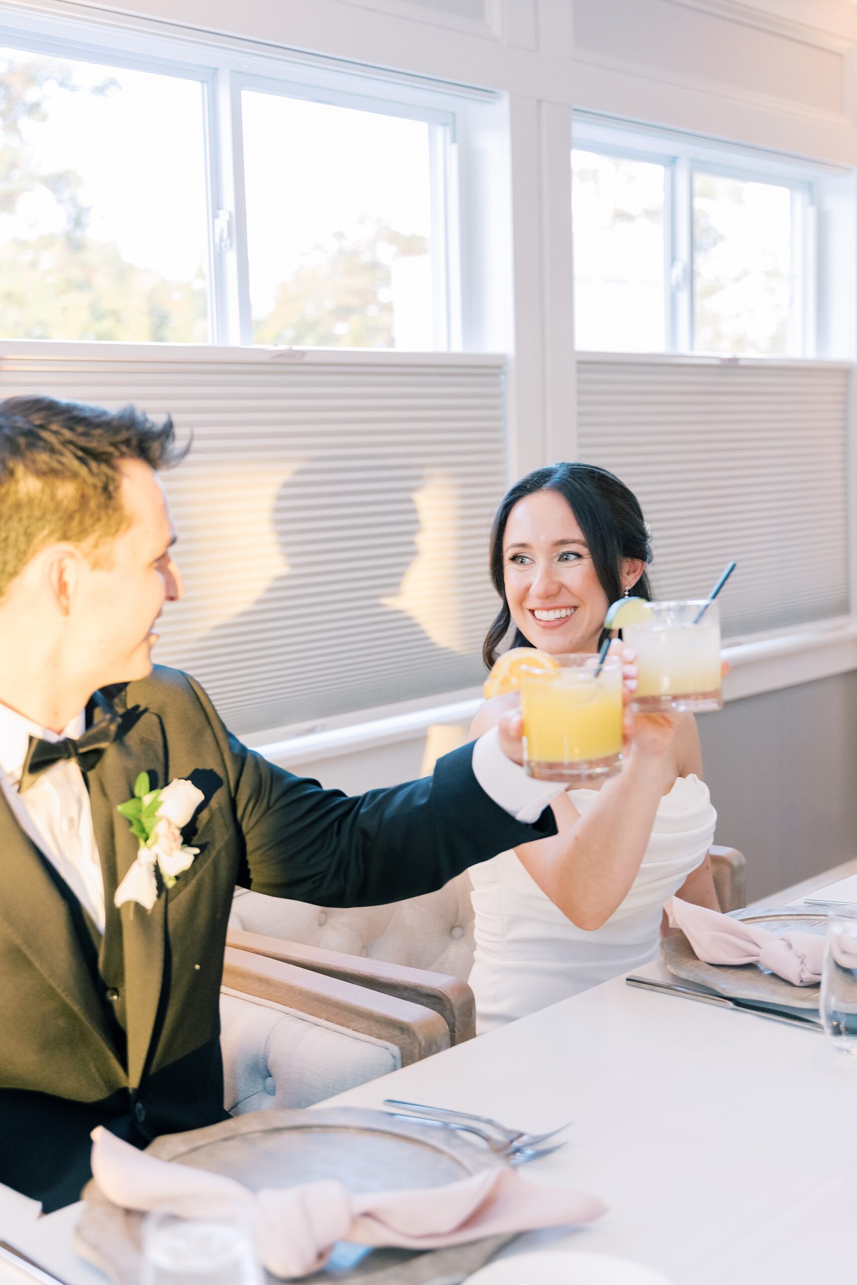 bride and groom toast signature drinks during reception at Herrington on the Bay