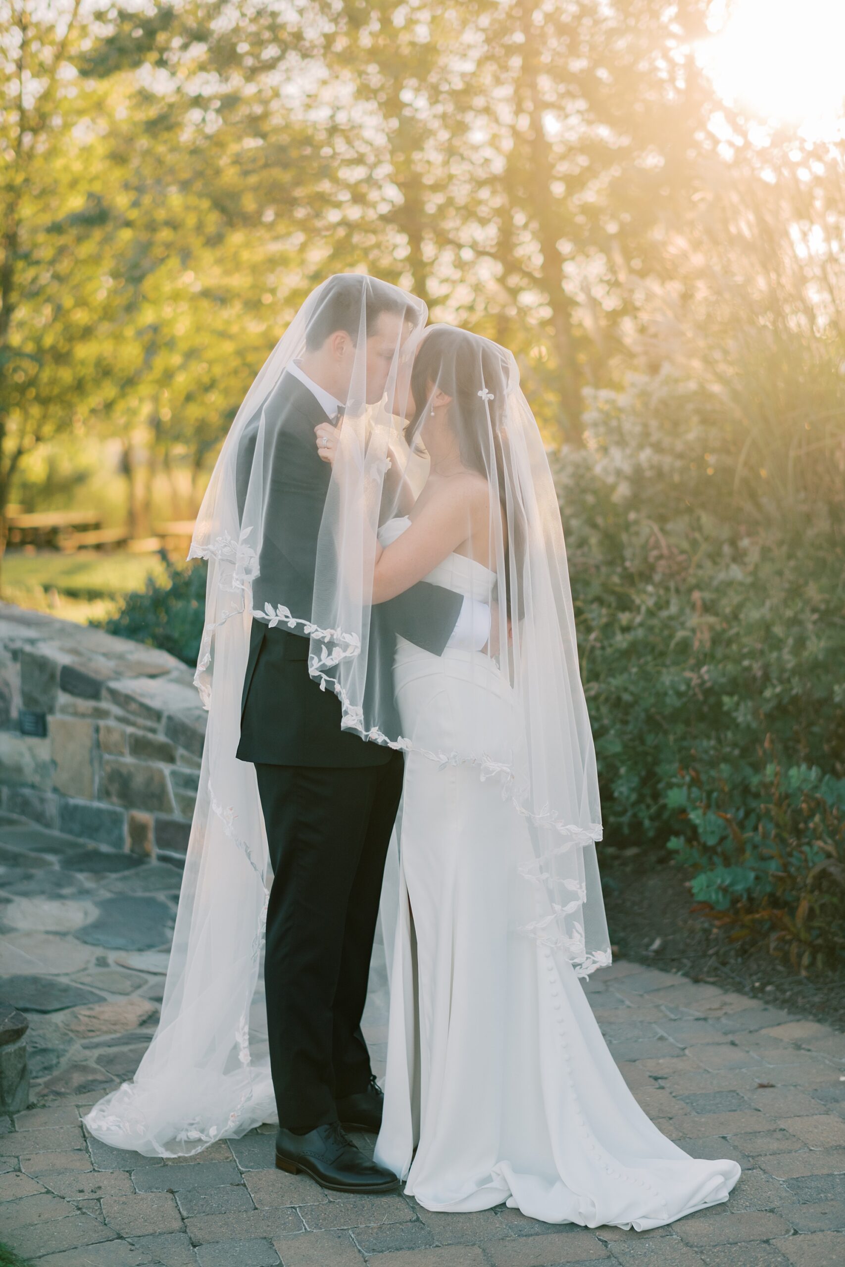 newlyweds hug under veil at Herrington on the Bay