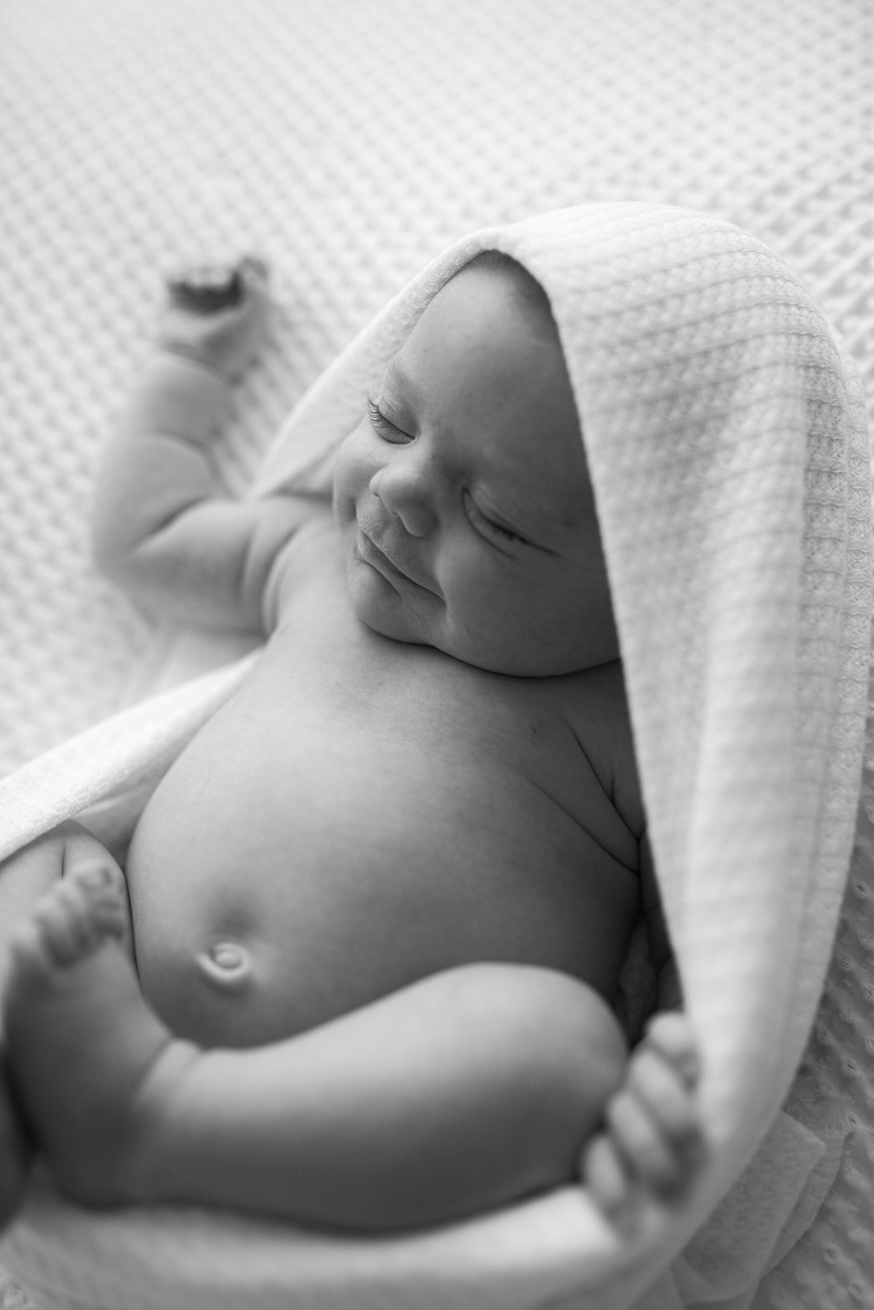 black and white photo of baby girl during studio newborn session in Solomons Maryland