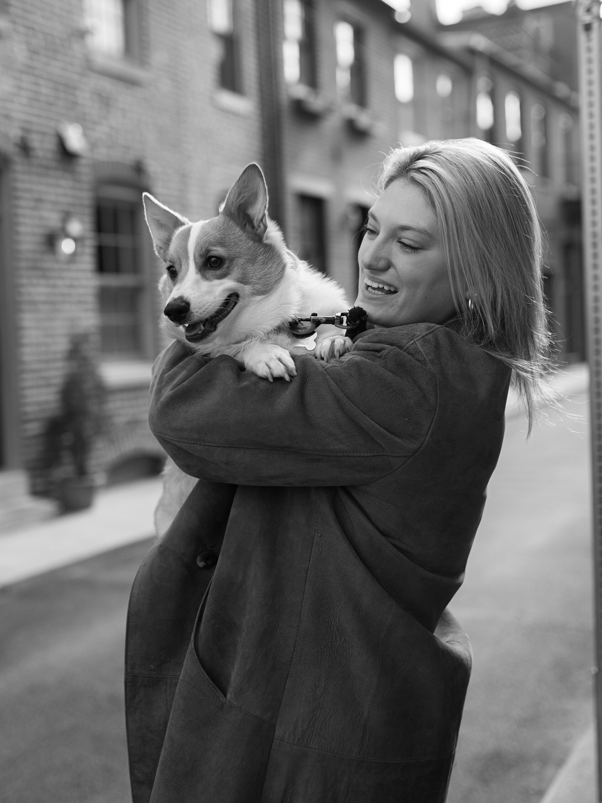 woman holds corgi dog in Fells Point neighborhood 