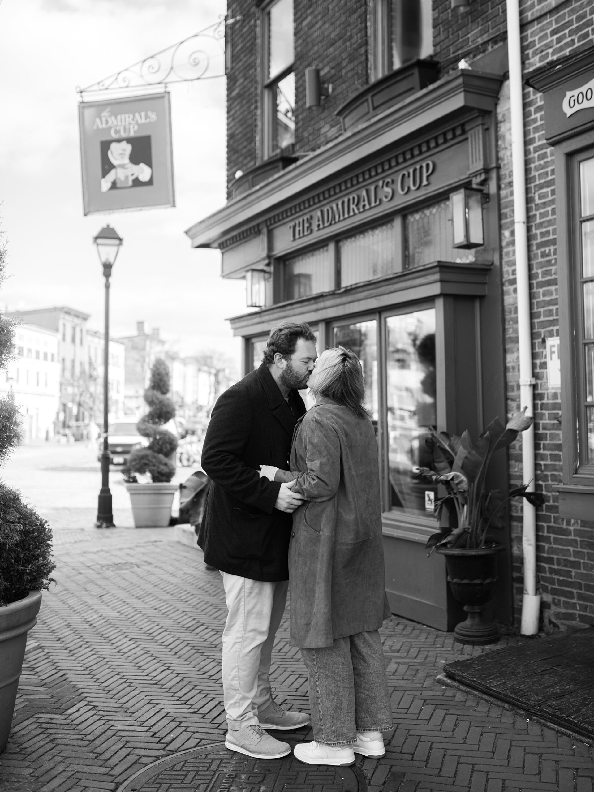 engaged couple kisses outside bar in Baltimore MD