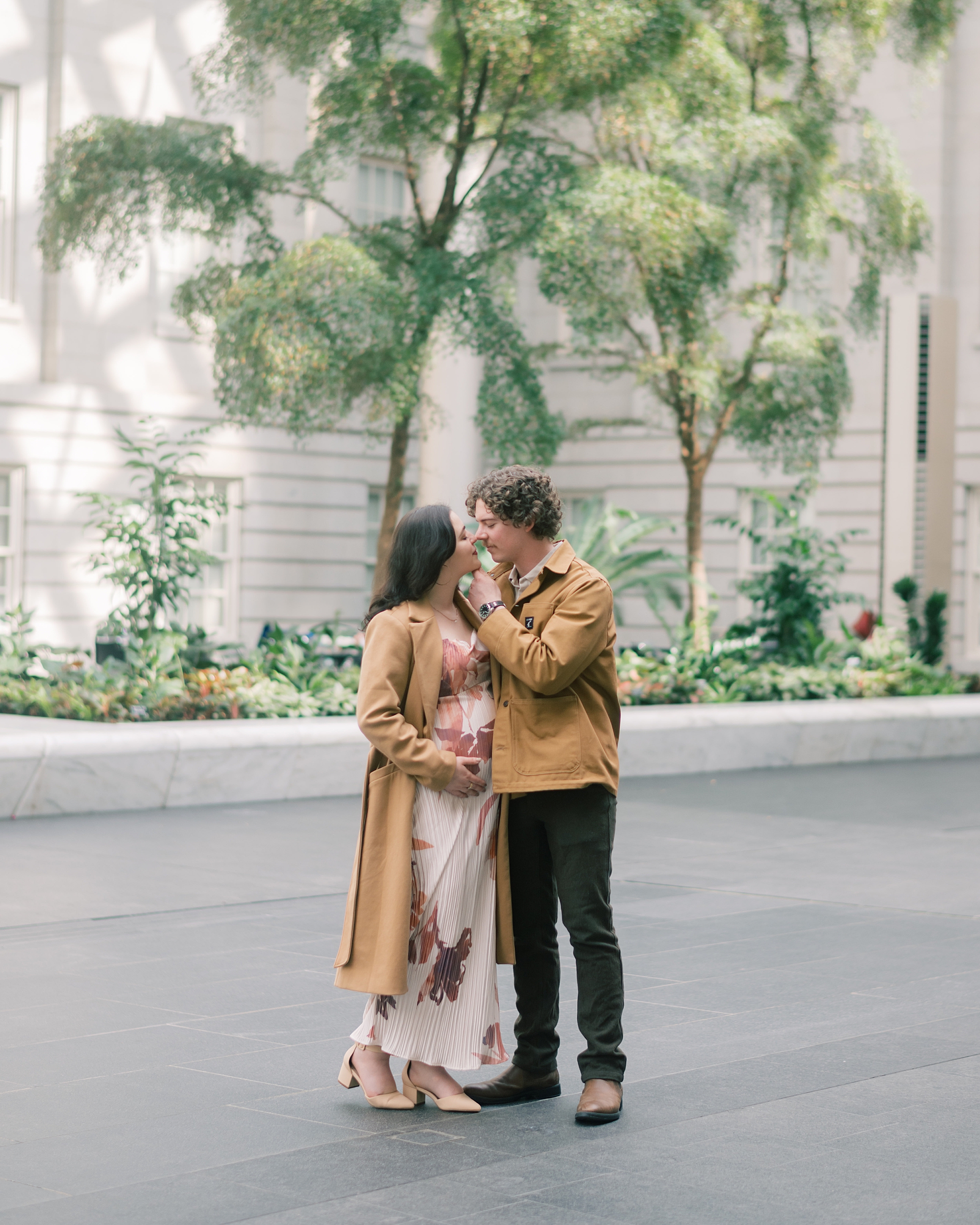man and woman kiss during maternity portraits in Washington DC
