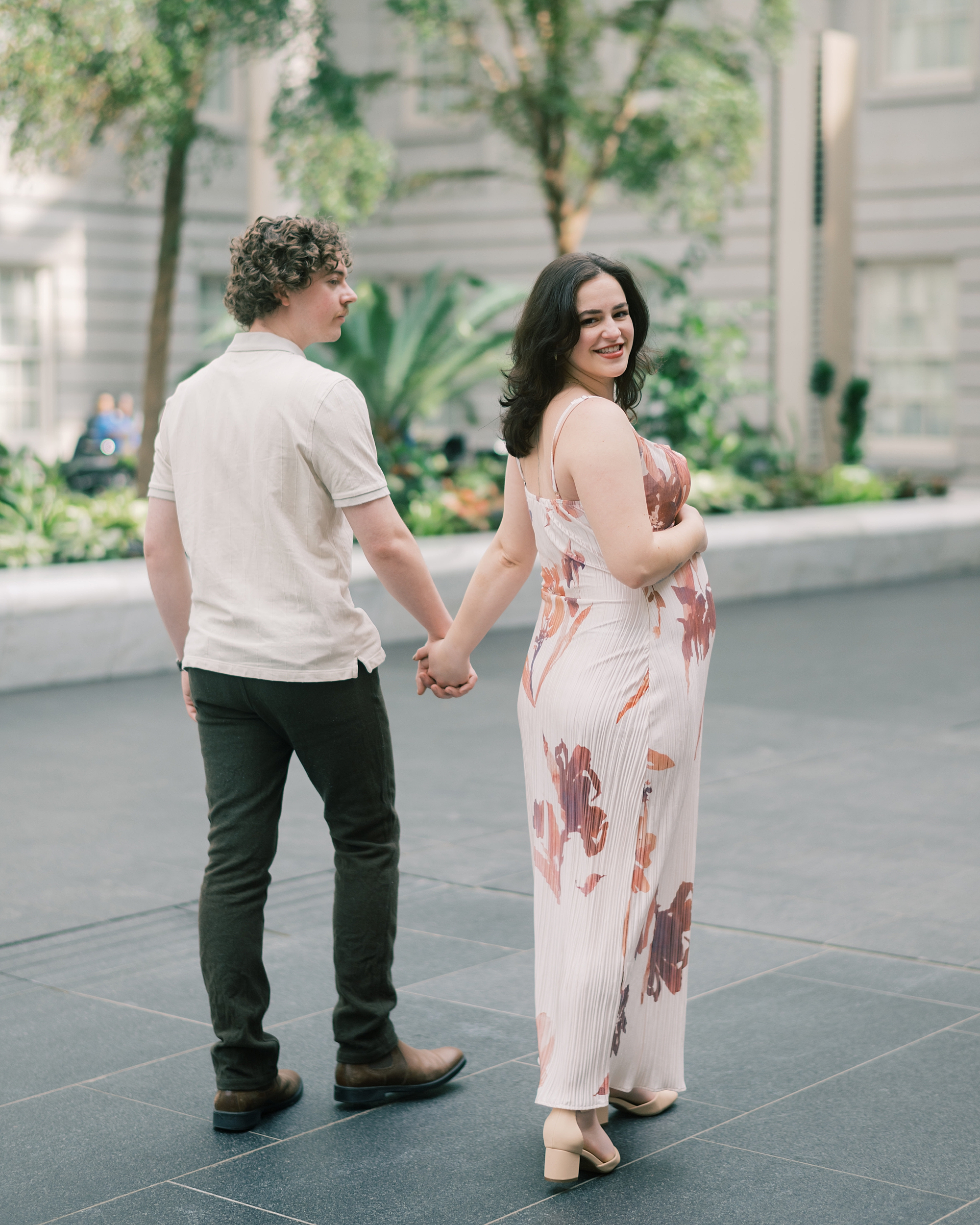 couple holds hands walking outside DC museum