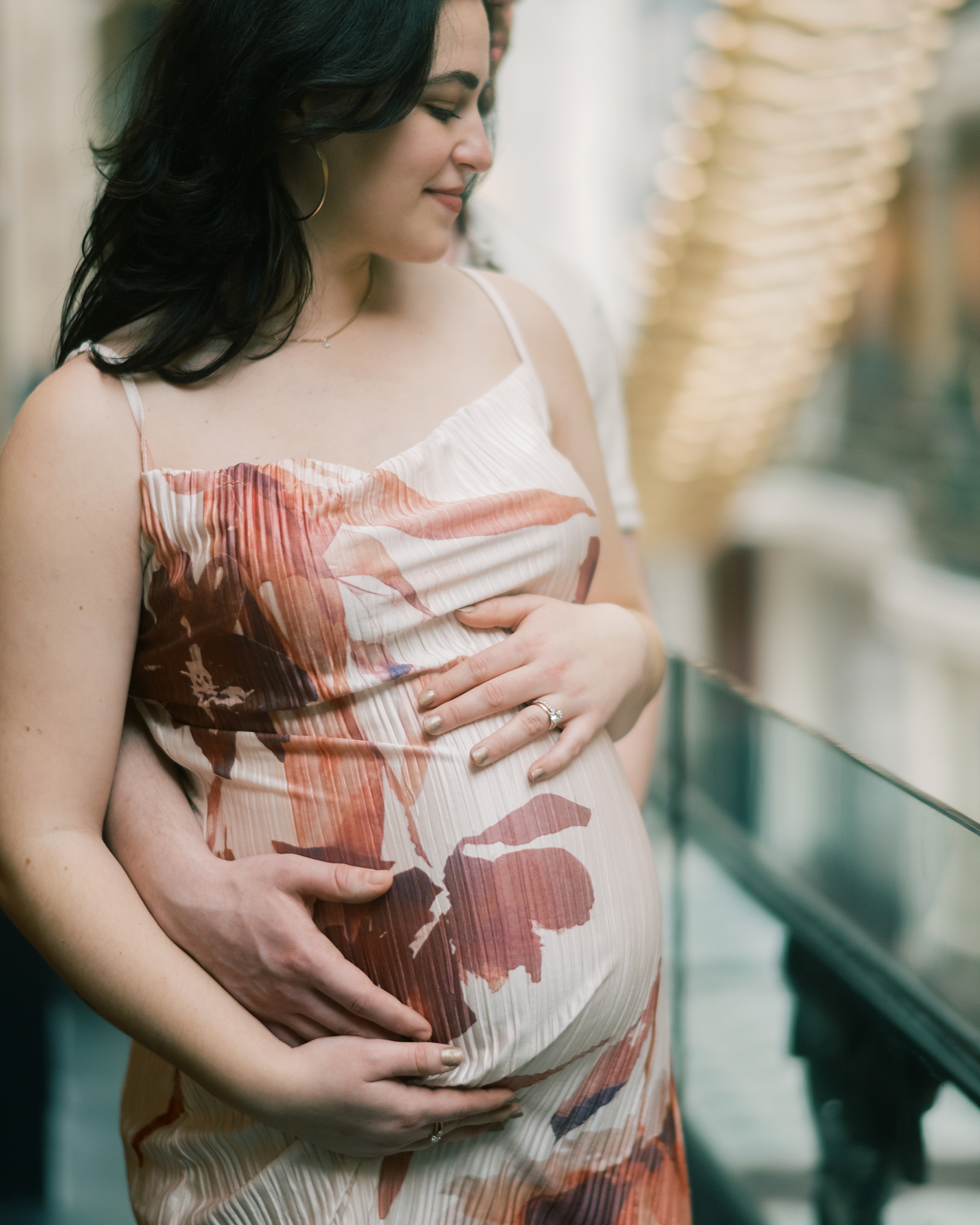 man holds woman's baby bump on balcony inside the National Portrait Gallery