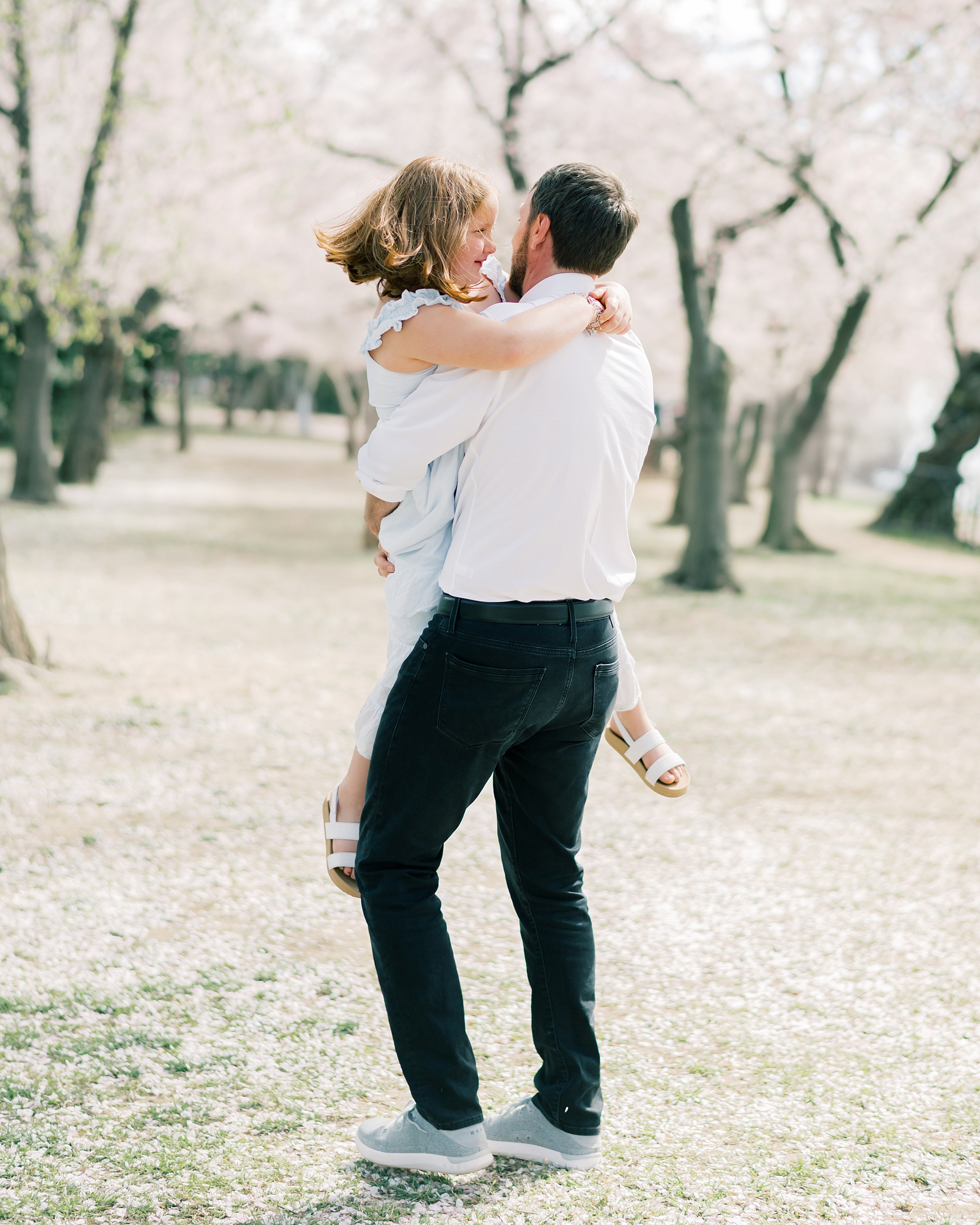 dad twirls around daughter during spring family photos in Washington DC