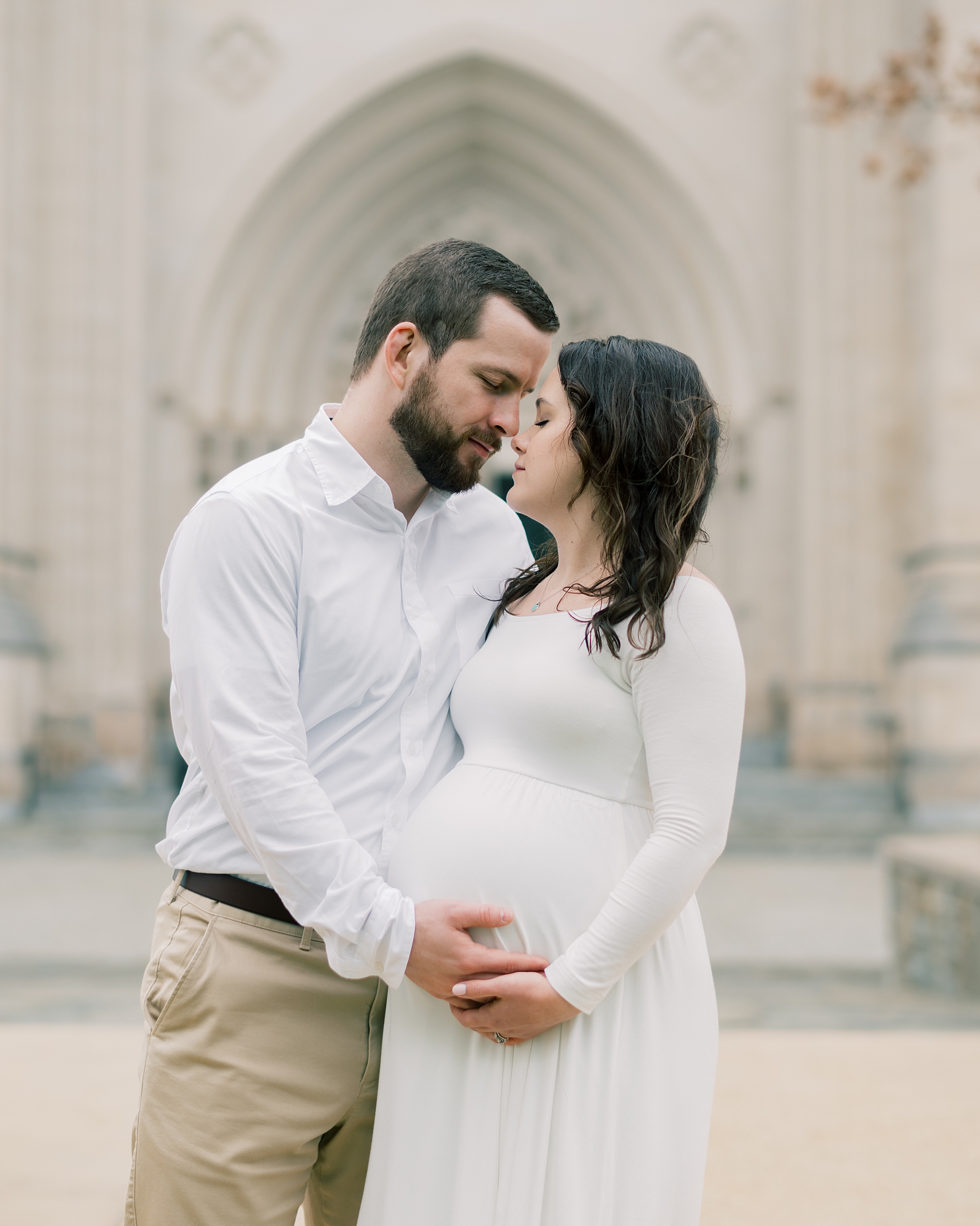 man and woman lean nuzzling noses during maternity session at the Washington National Cathedral