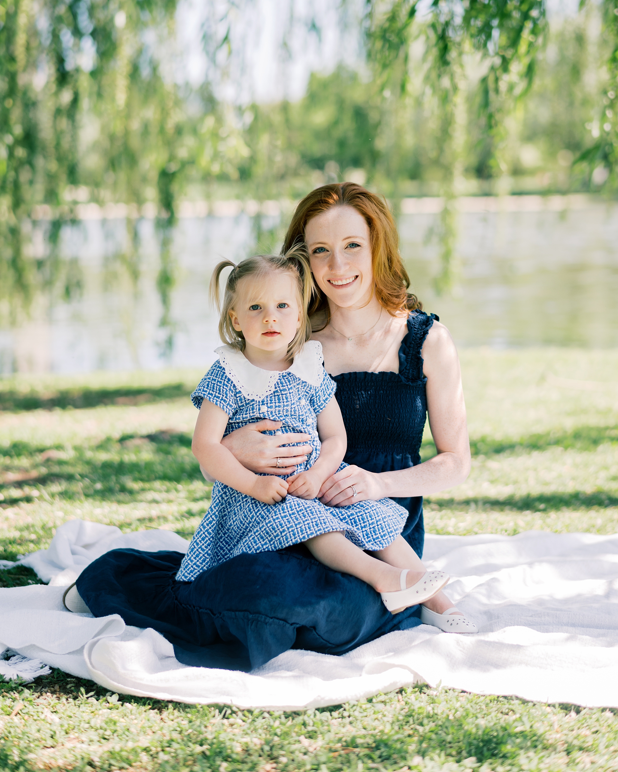 mother sits on blanket with daughter during DC family photos