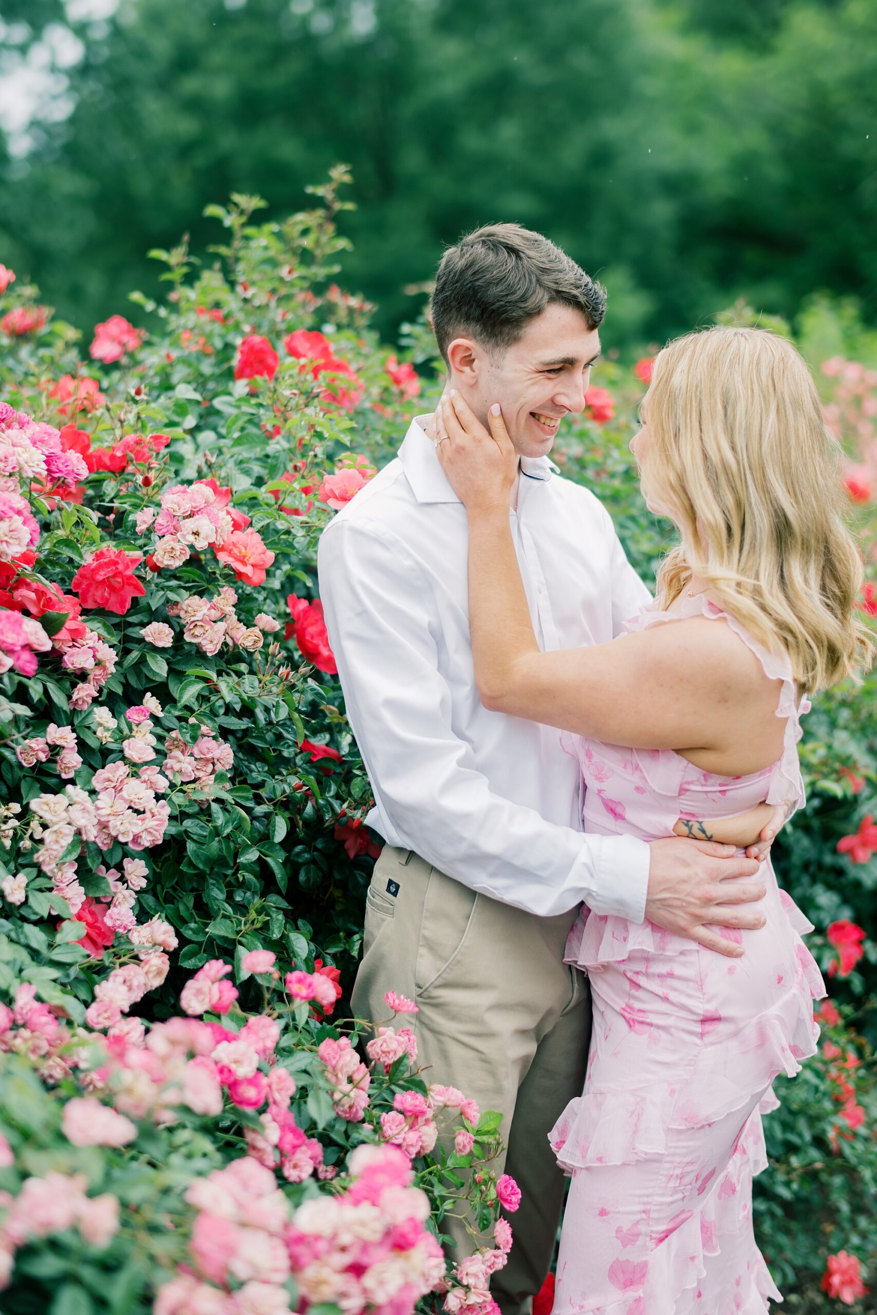woman looks up at man during garden engagement session in Arlington VA