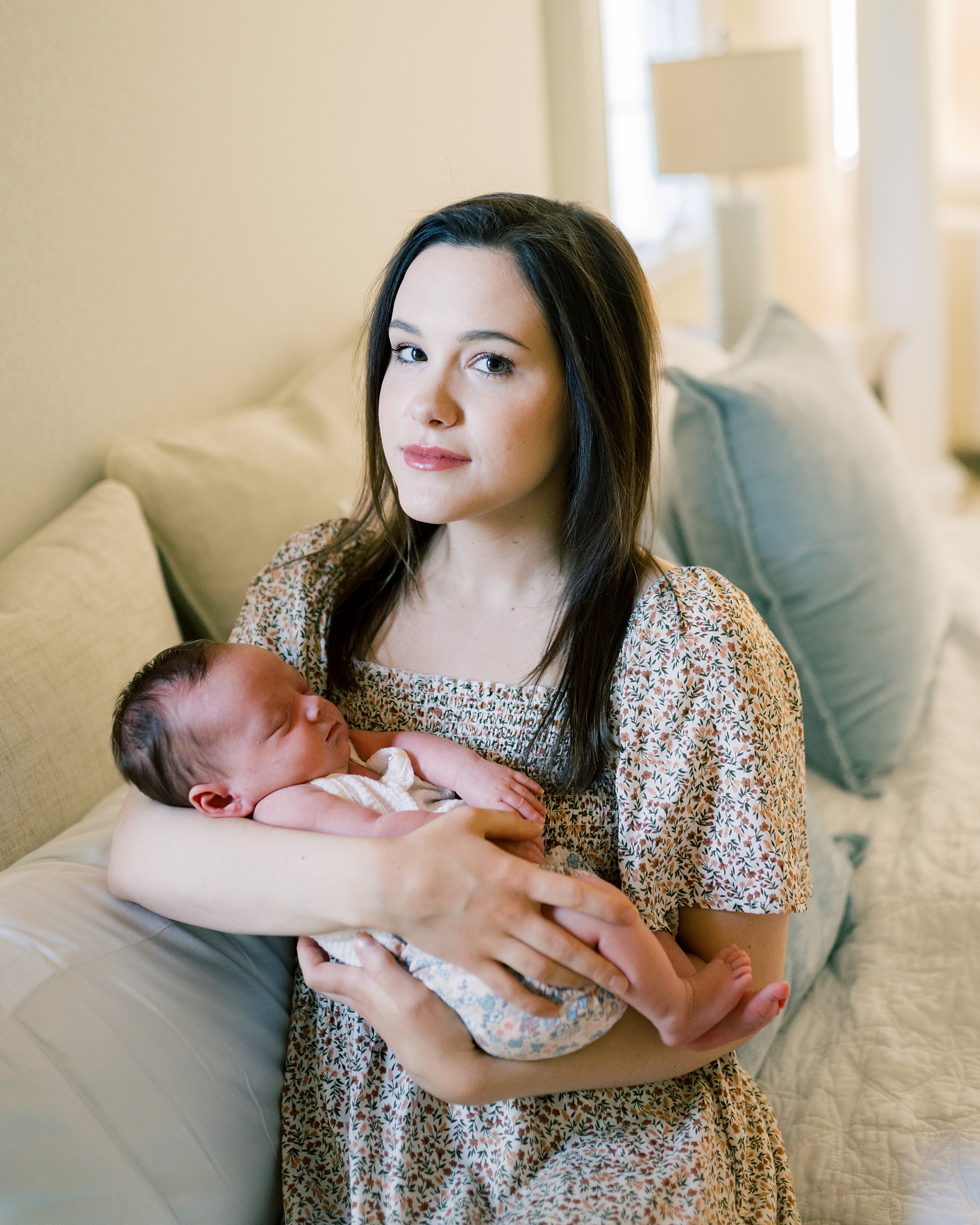 mom holds newborn smiling at camera lightly