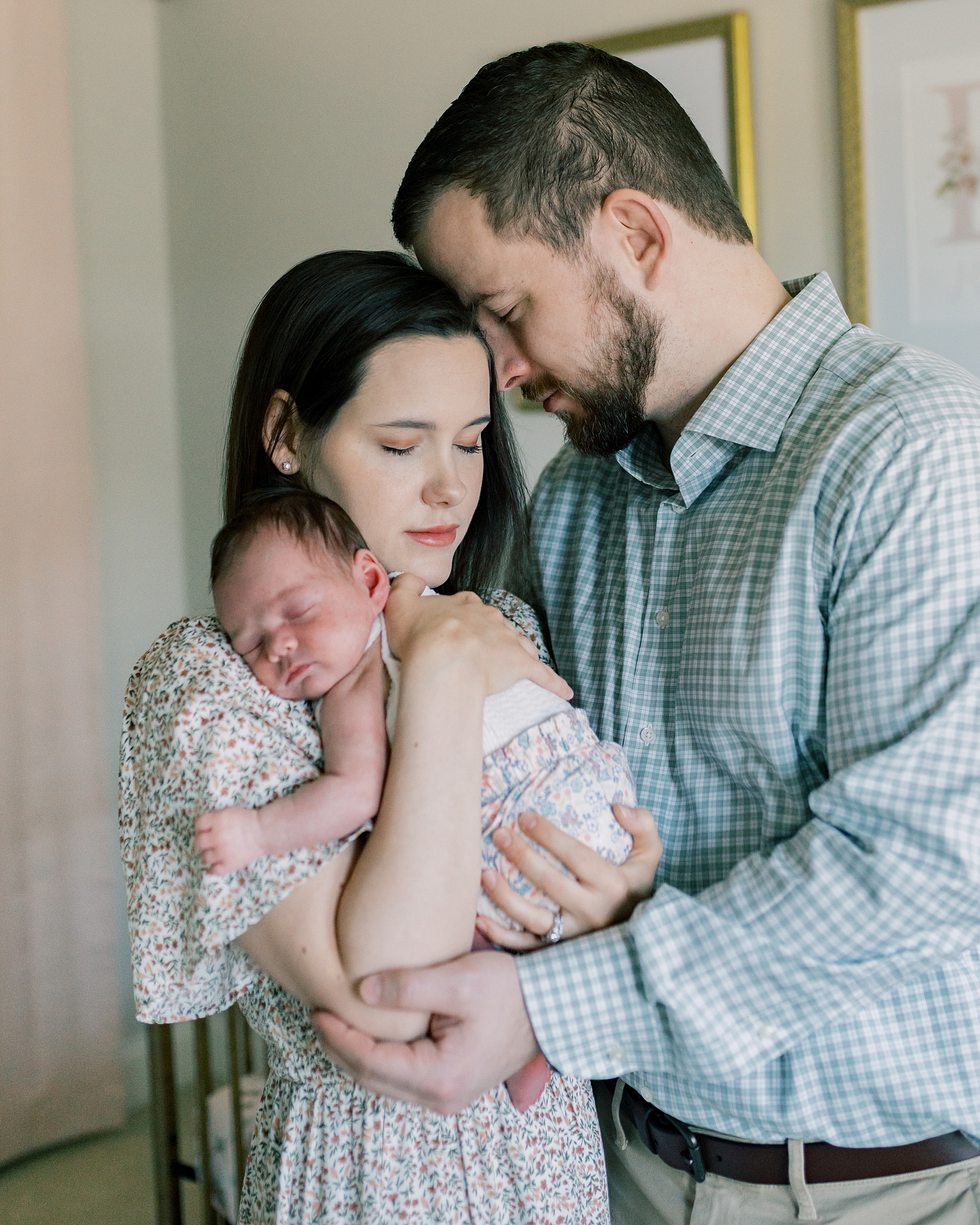 mom and dad hug newborn baby girl in nursery during newborn session at home in Washington DC