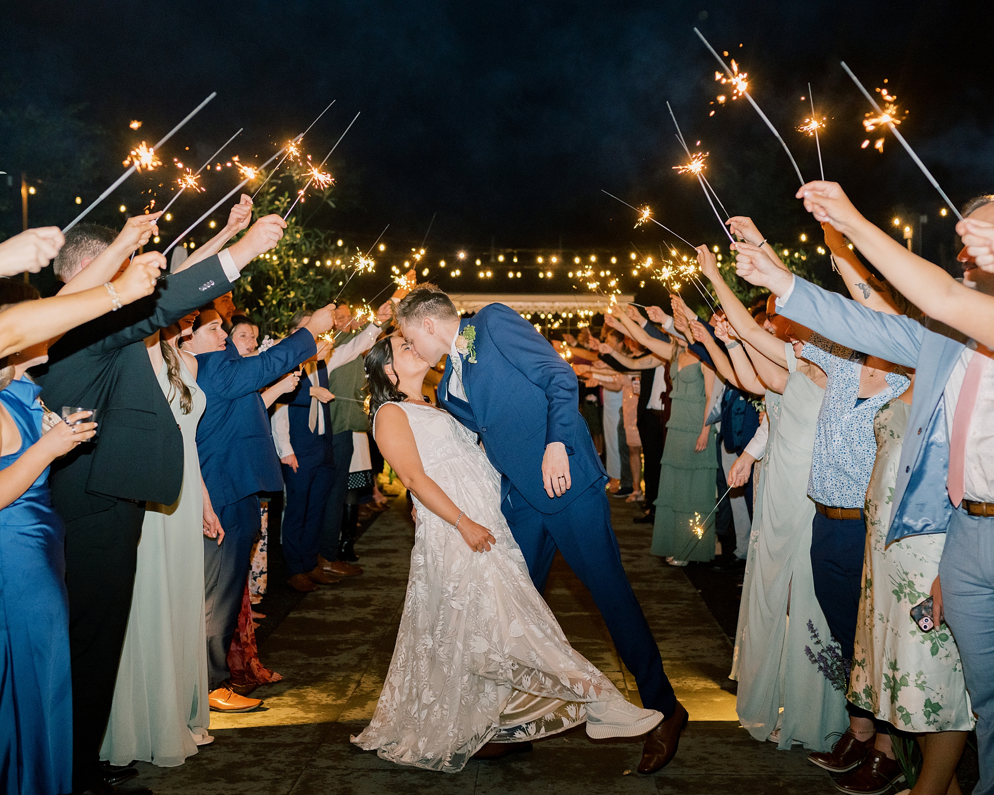 groom dips bride kissing her during sparkler exit