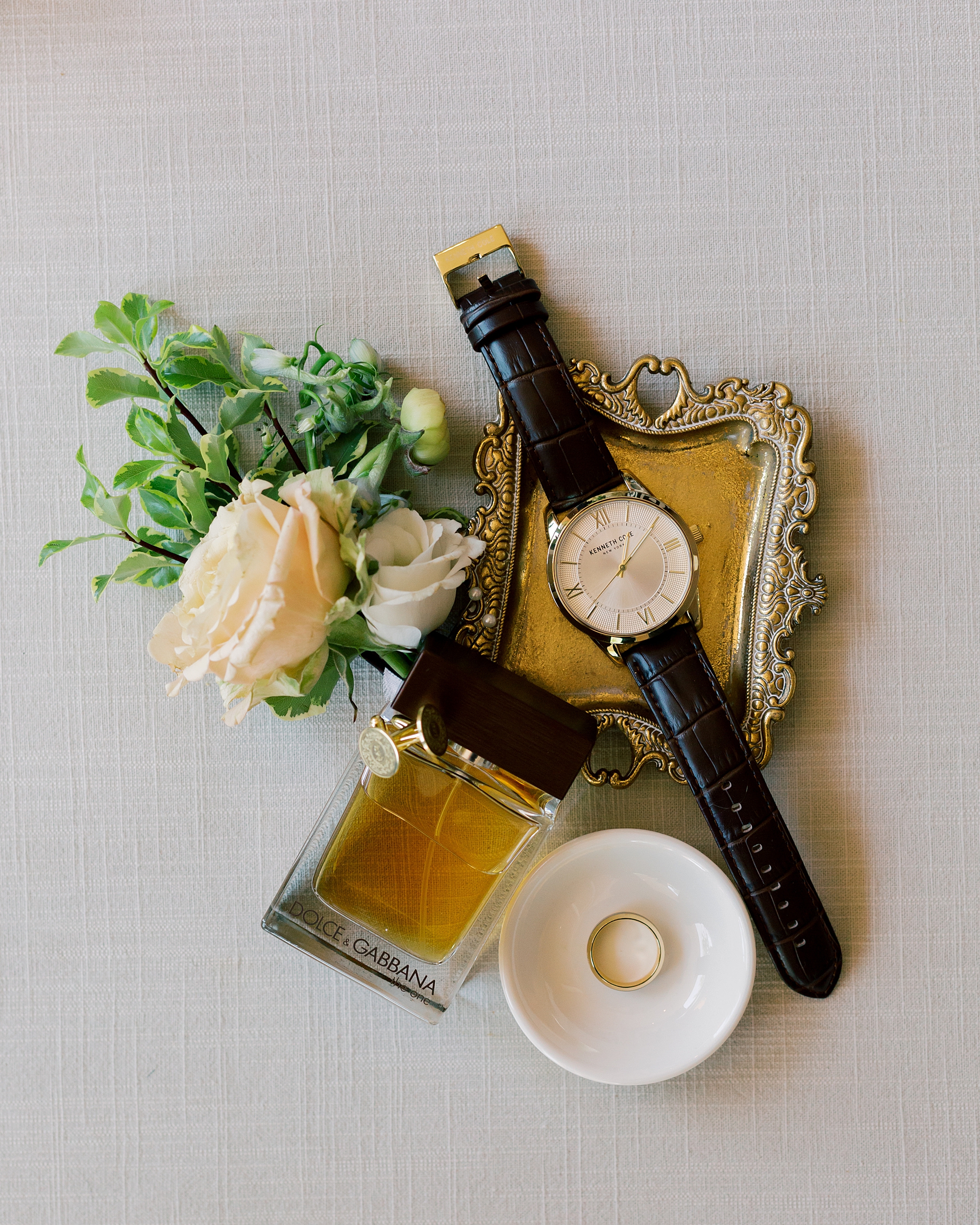 groom's watch and boutineere on gold tray