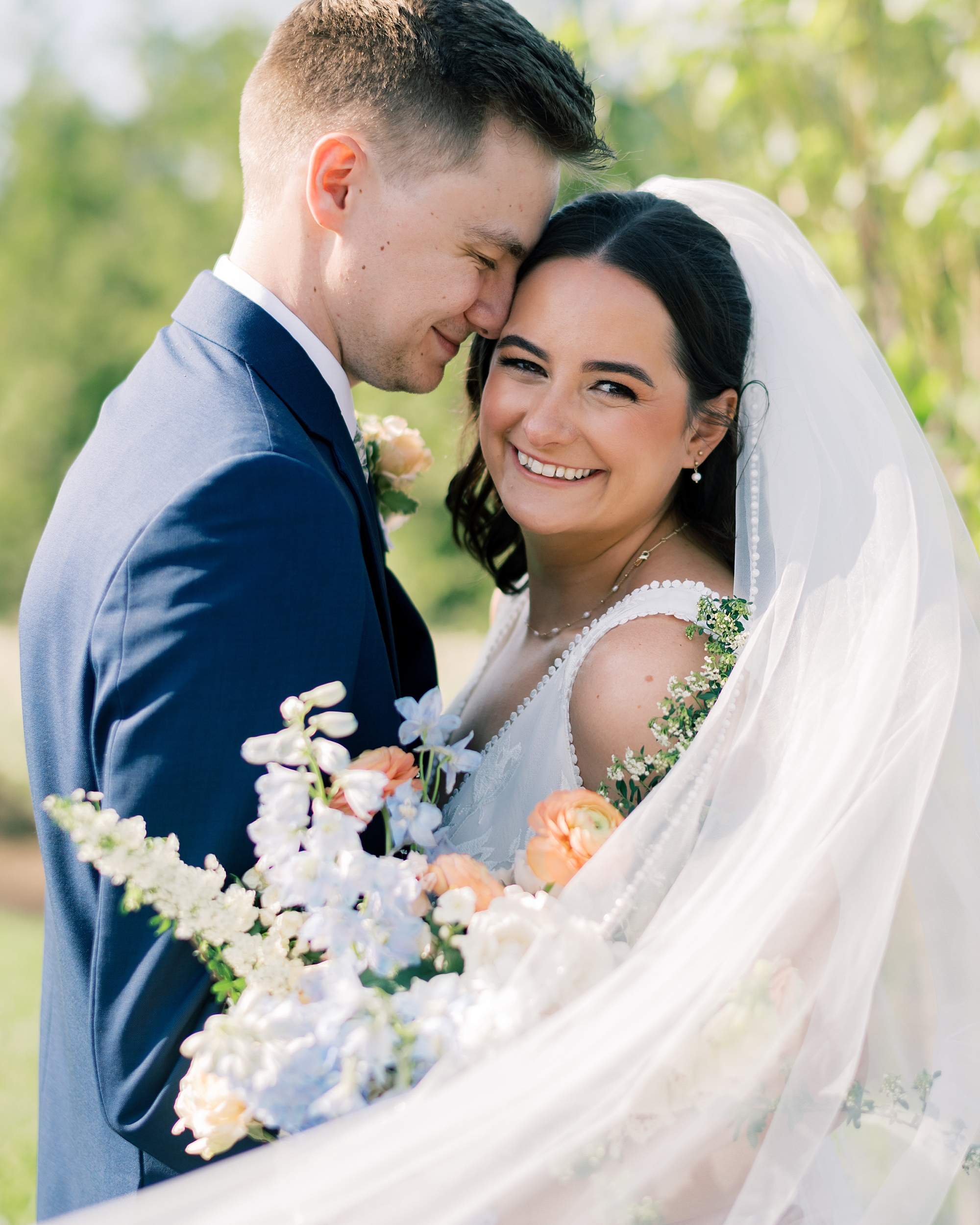 bride and groom hug with bride's veil pulled around them