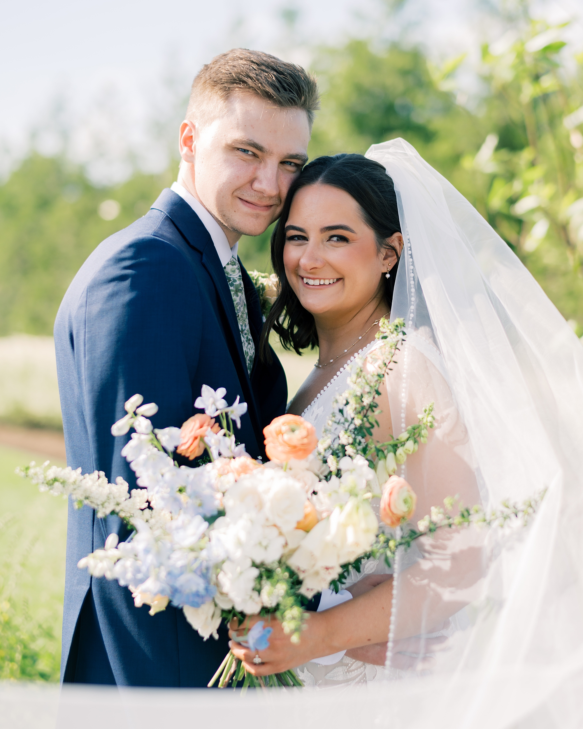 bride and groom hug touching heads together during spring wedding photos at Terrain Gardens