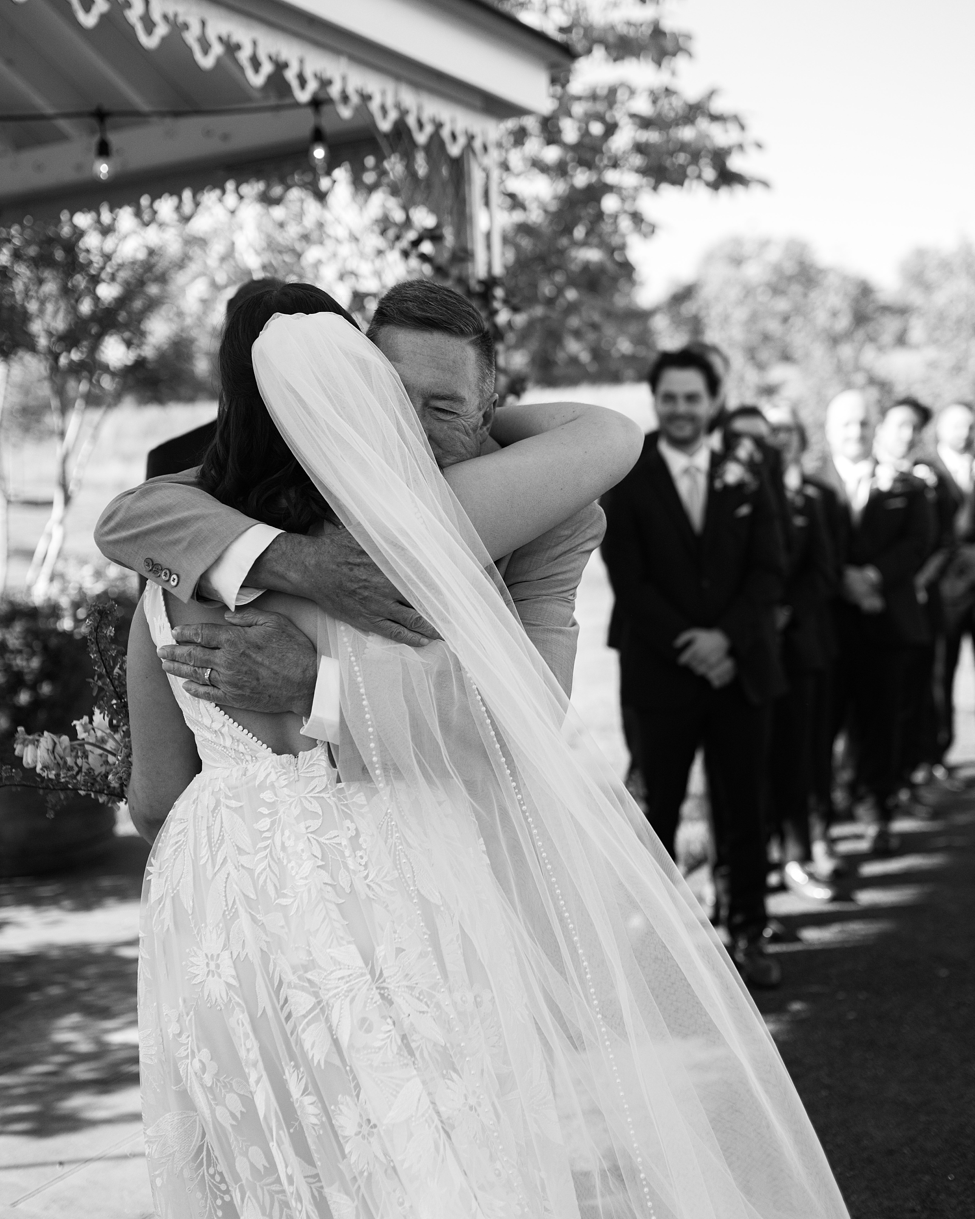 bride hugs father during wedding ceremony at Terrain Gardens