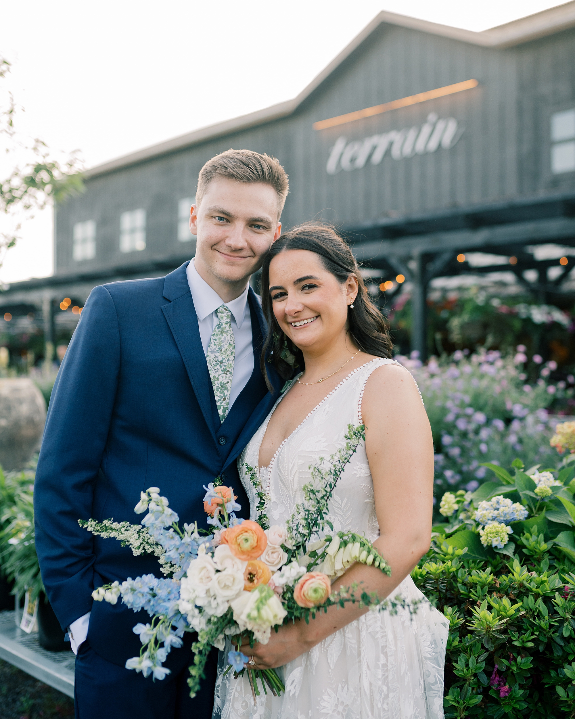 bride and groom smile standing together outside Terrain Gardens