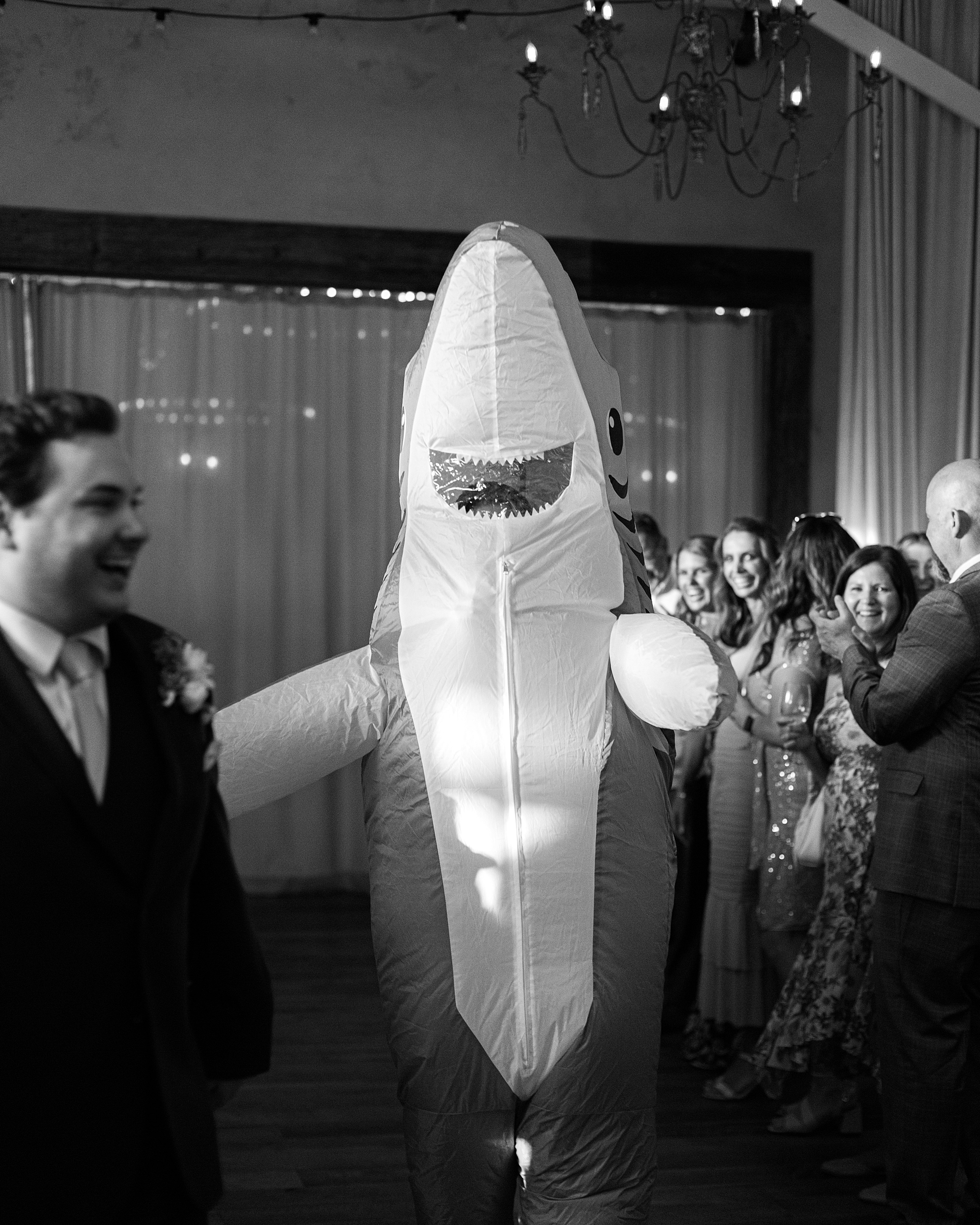wedding guest wears inflatable shark on dance floor