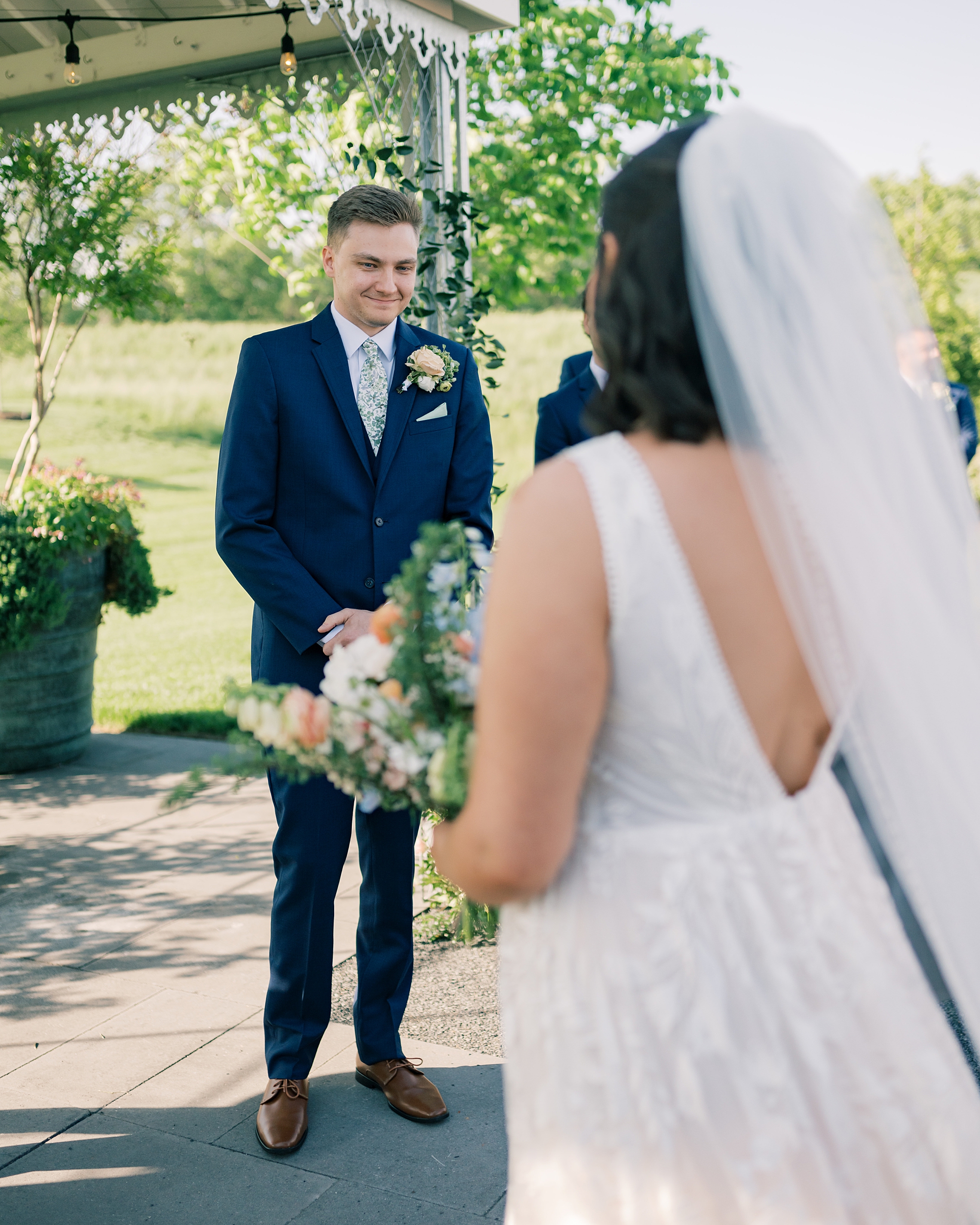 groom grins at bride during ceremony at Terrain Gardens