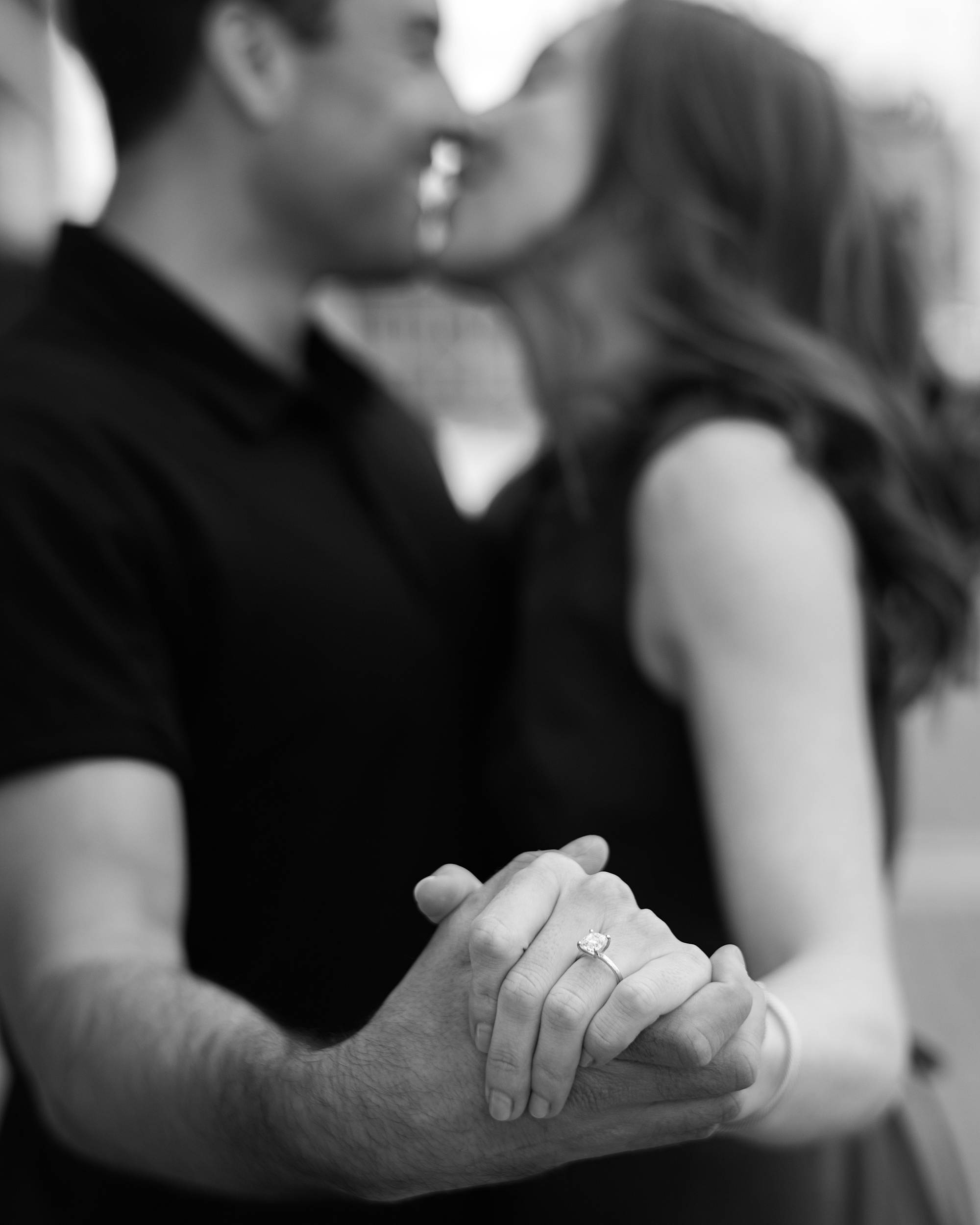 engaged couple holds hands showing off woman's ring