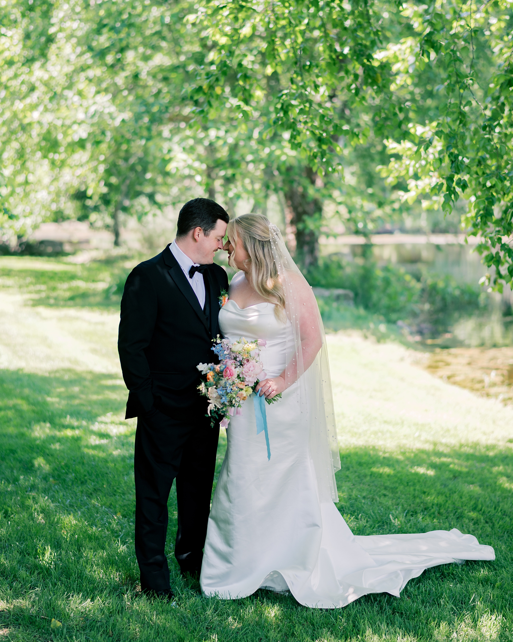 newlyweds hug under tree at Olde Breton Inn