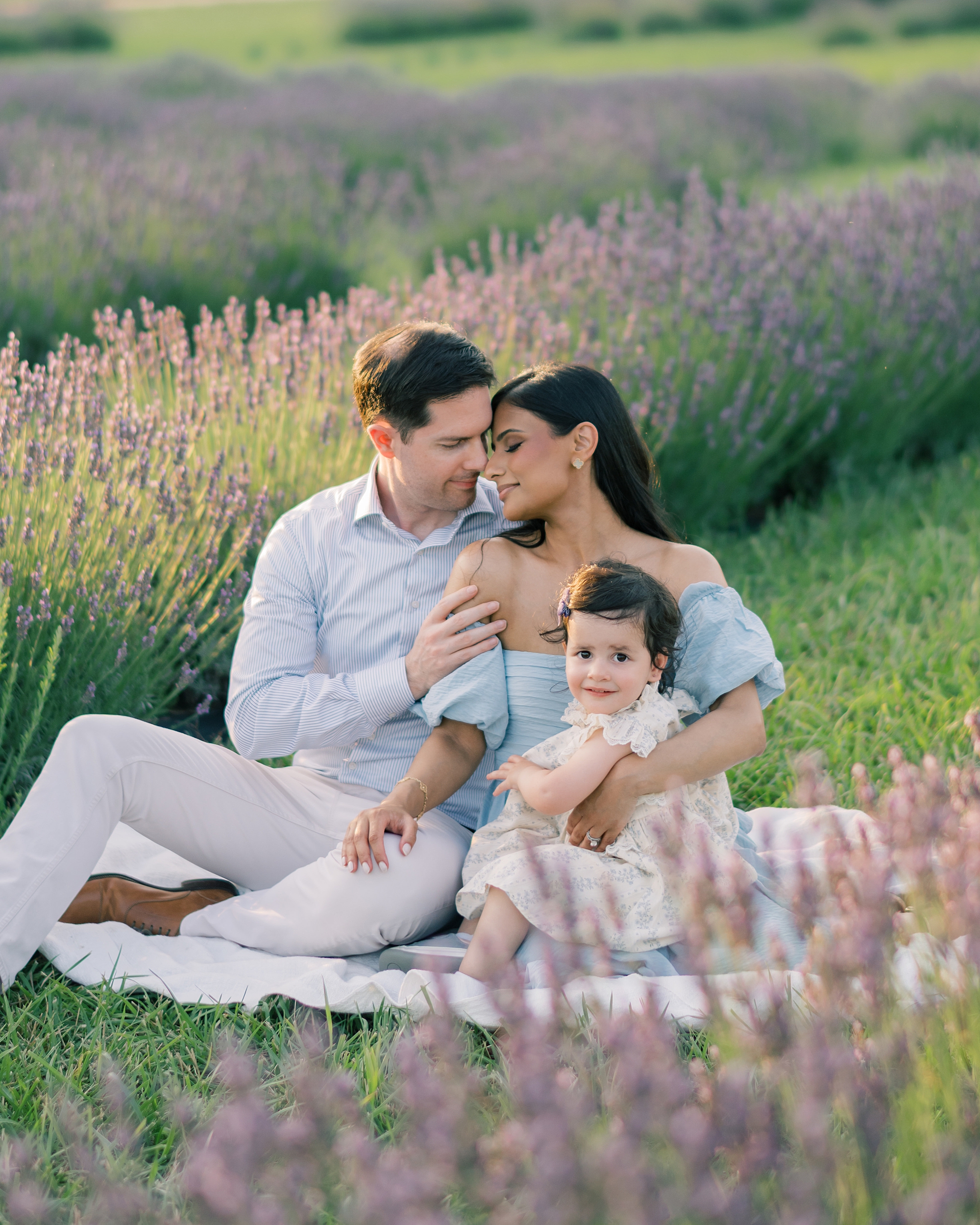 family of three sits on blanket in lavender field in Hollywood MD