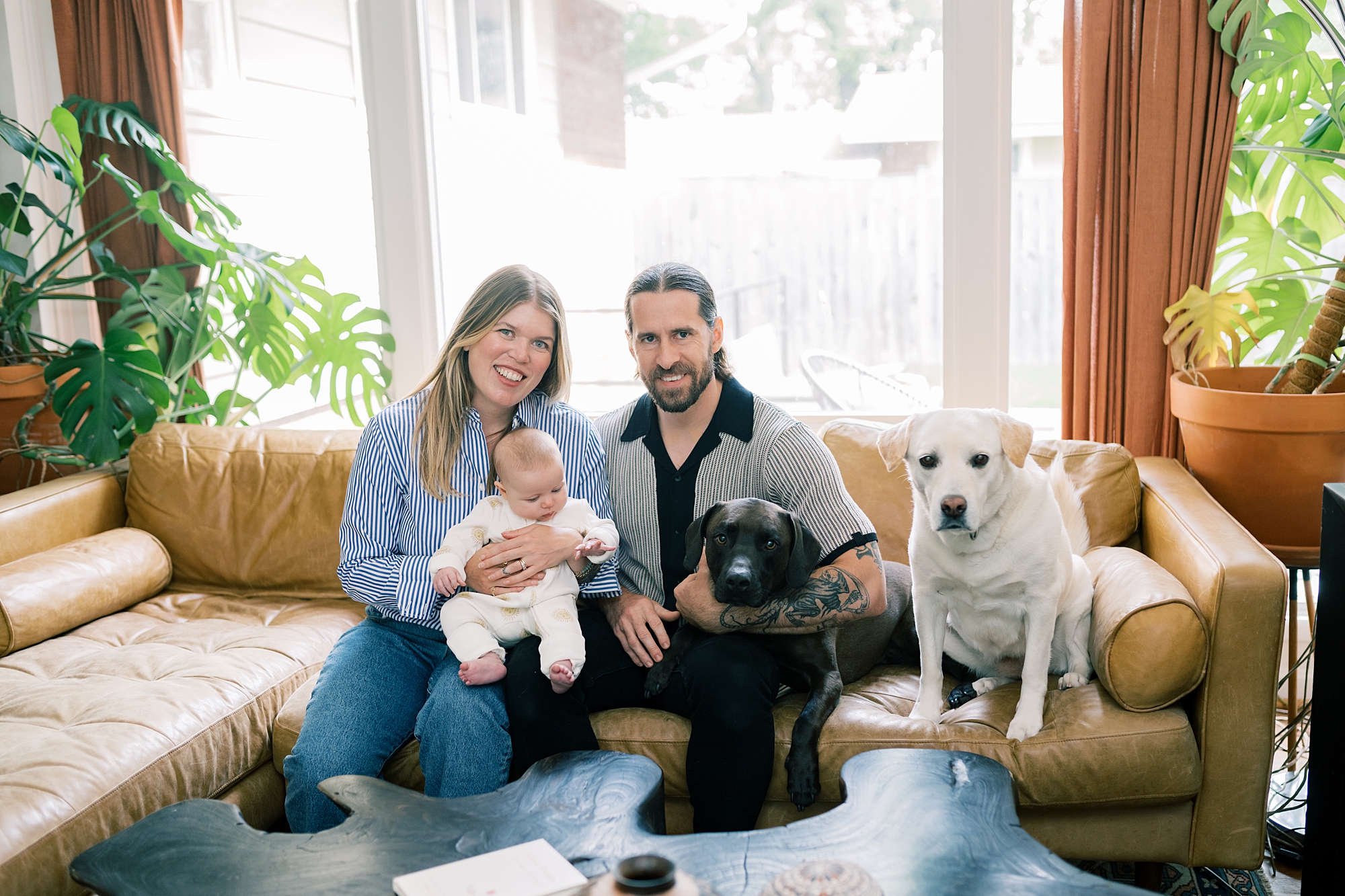 family sits on couch with two dogs in Washington DC home