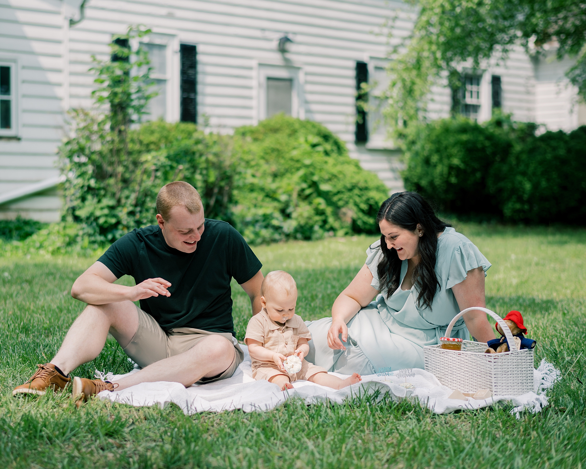 family sits on front lawn of Maryland home during first birthday session