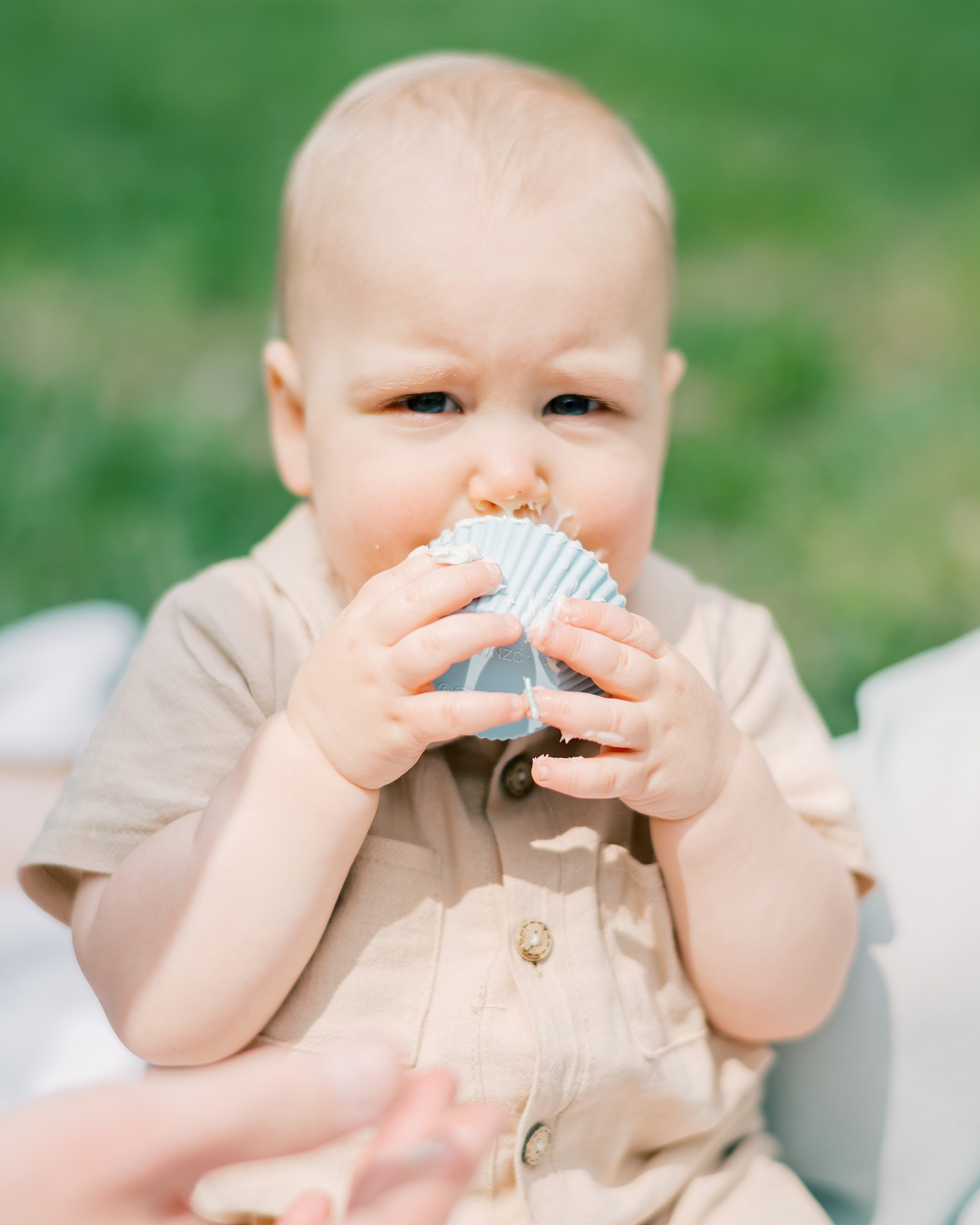 baby licks icing on cupcake during Paddington inspired first birthday portraits