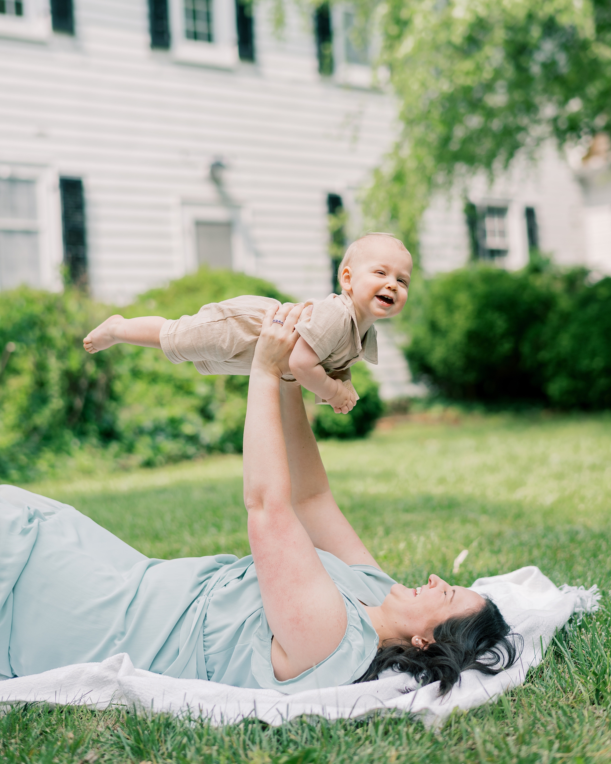 woman lifts baby on lawn of Maryland home 