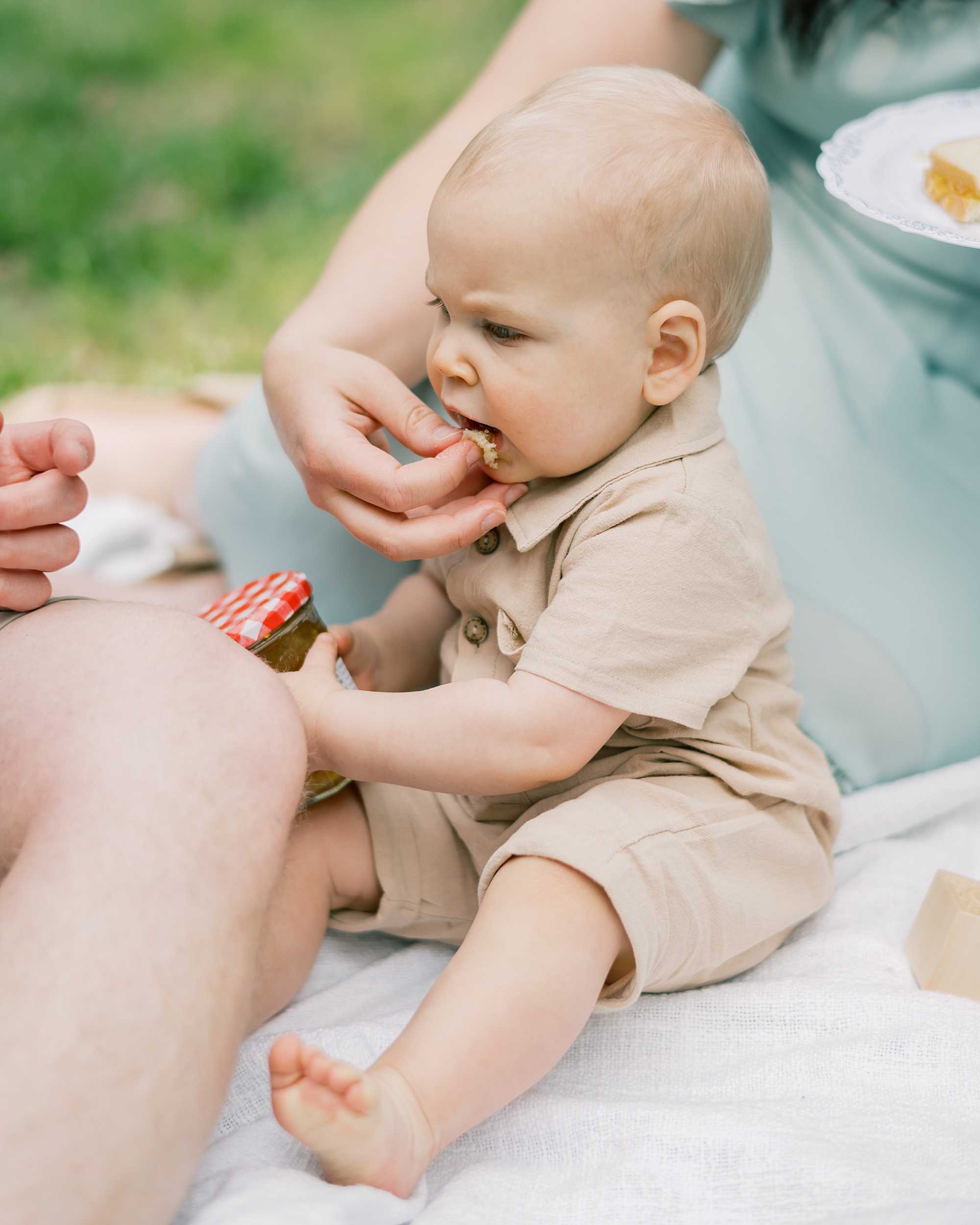 mom feeds baby cake during Paddington inspired first birthday portraits